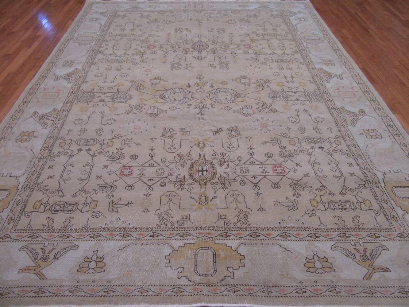 This is a beautiful hand-knotted wool rug was made in Egypt. It has an all-over Agra design on an beige color field with a flat antique look. The rug measures
9' x 11' 9''.