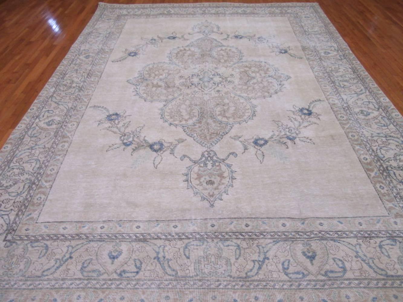 This is a beautiful hand-knotted distressed old Persian Tabriz rug. It has the cool contemporary and popular colors mixed with a more traditional pattern creating a great transitional rug to work with. It measures 9' 6'' x 12' 7'' and in good shape.