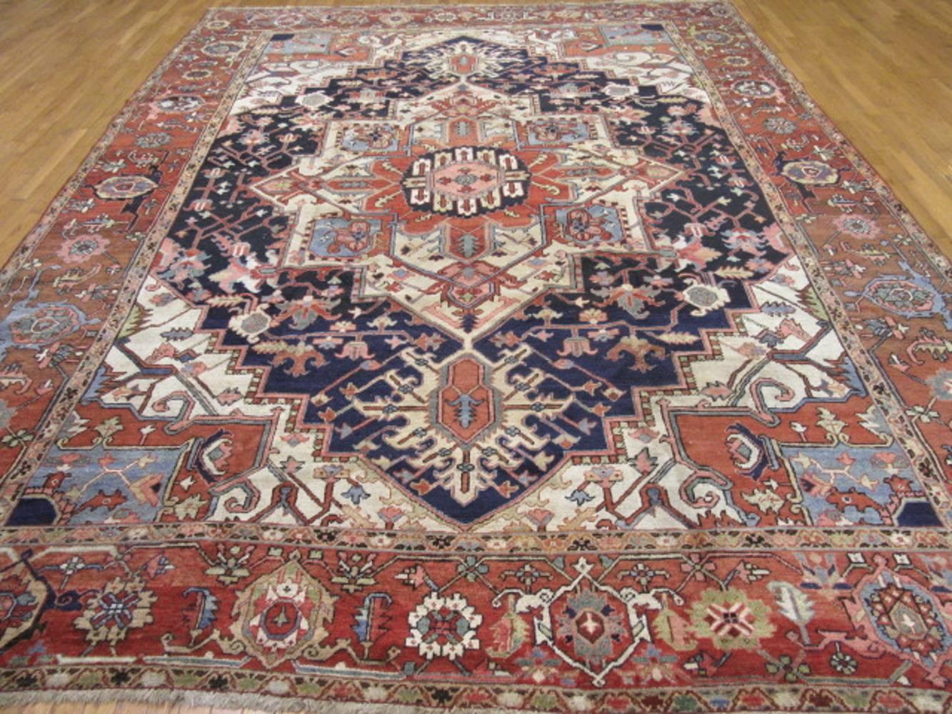 This is a room size hand-knotted antique Persian Serapi rug for the northwest region of Iran. Nomadic yet elegant, Heriz / Serapi rugs have always been a popular type of rug for color, design and ease of use. It measures approximately 10' x 13' and