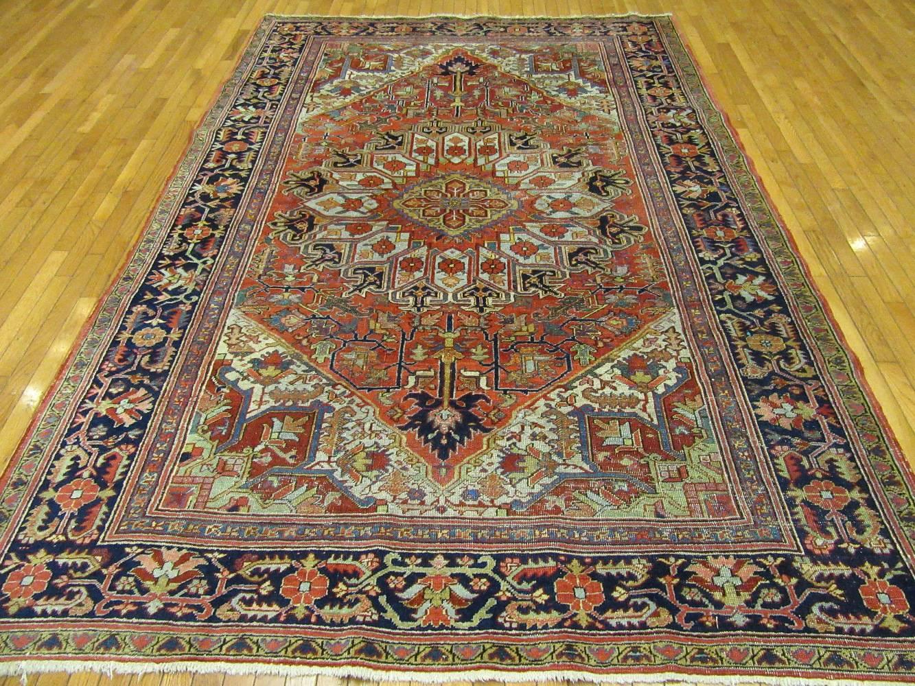 This is an antique hand-knotted rug from the infamous village of Heriz in northwest Iran (Persian).
This rug has the primary colors and a geometric central and corner medallion Heriz design made with wool and natural dyes. A very useful size for
