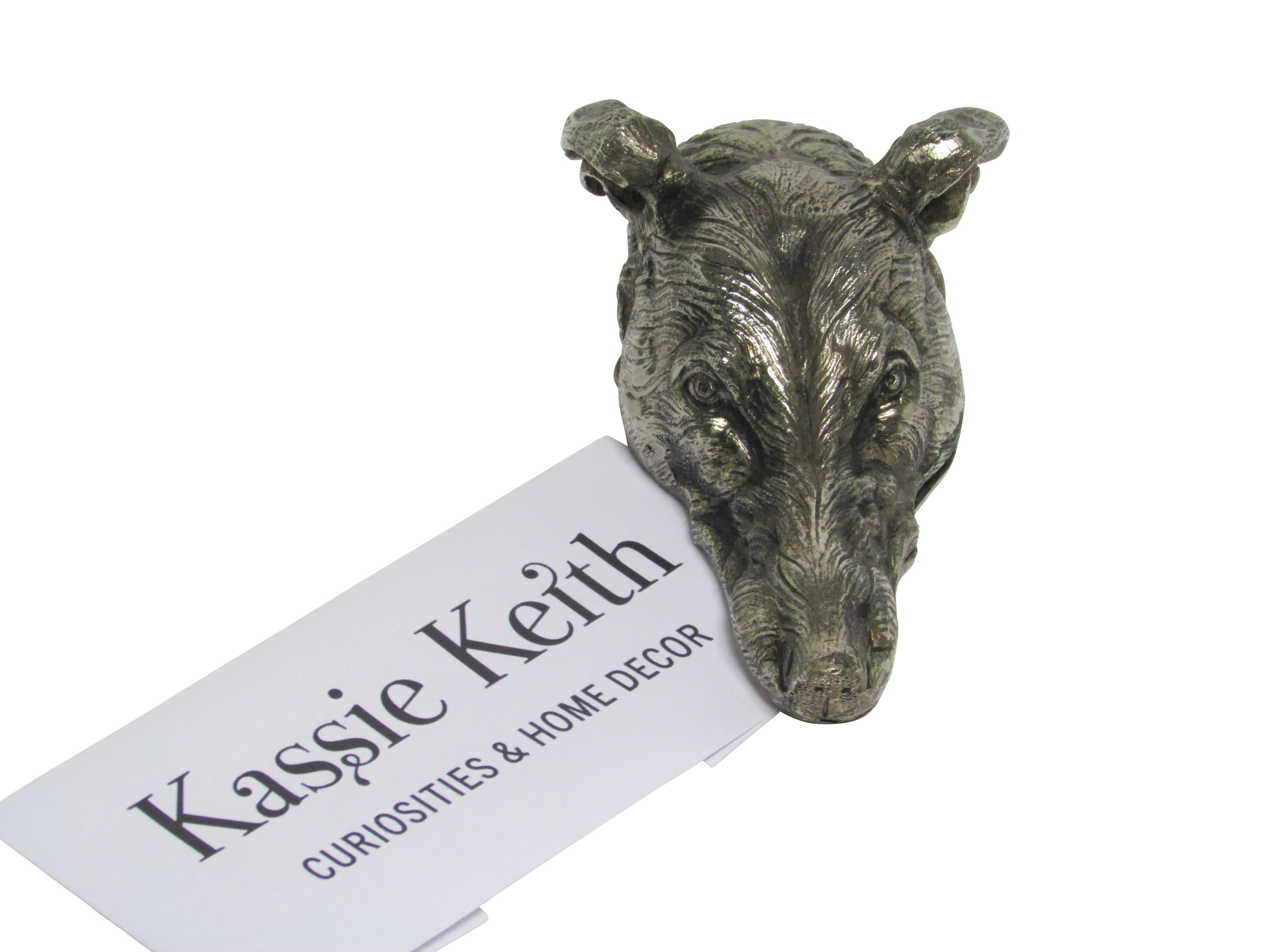 This is an early 20th century silvered bronze figural dog head letter clip.