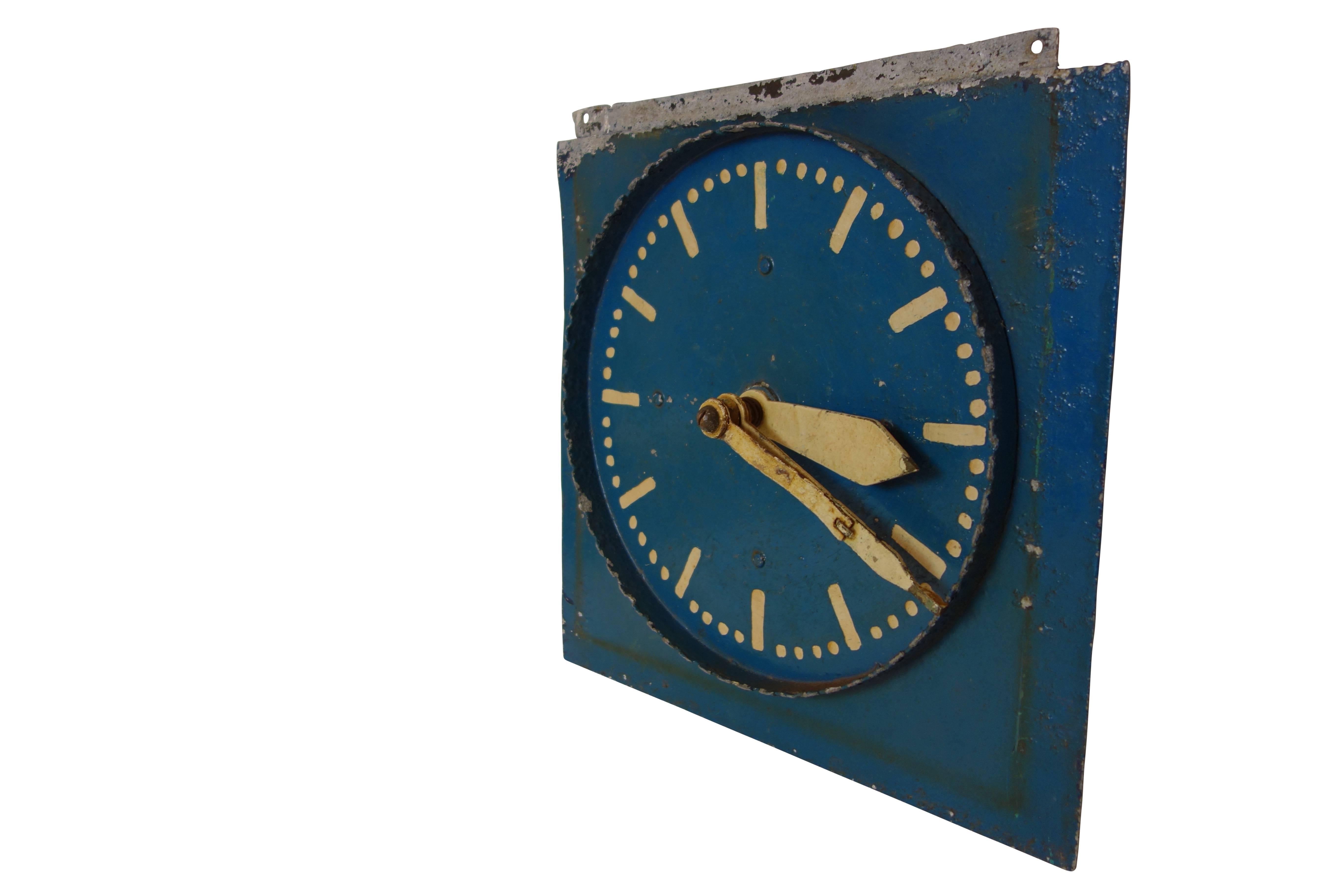 This is a unique hand-painted double-sided aluminum clock from Belgium that was most likely used as a teaching aid. With its original blue and white paint this is truly an eye catching piece. The hands on the clock can be manually positioned, with