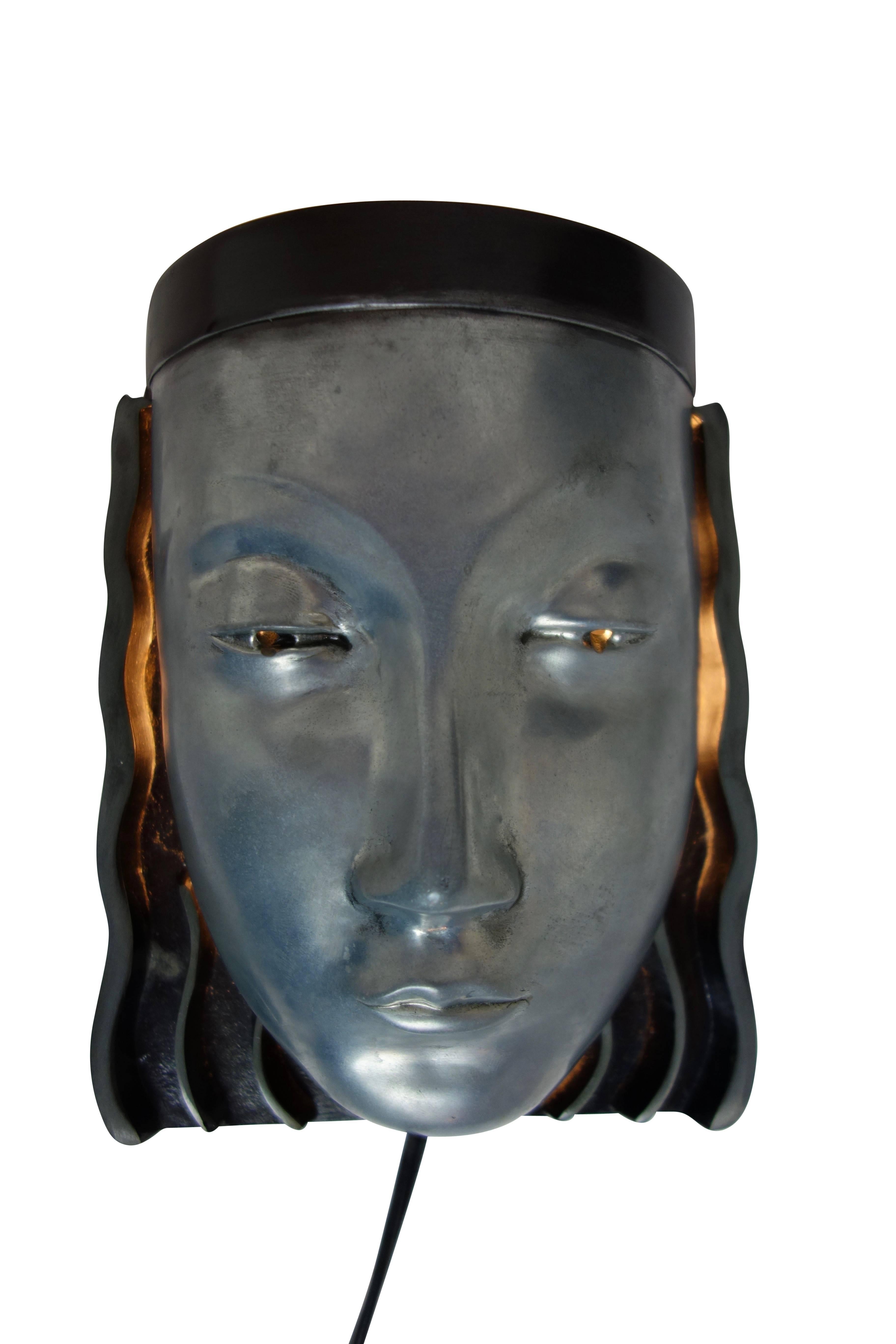 This is an Art Deco style wall sconce of an Egyptian. This is an Art Deco style wall sconce of an Egyptian princess circa 1975. When illuminated, the light shines out of her eyes and the top of her head. The back is stamped 