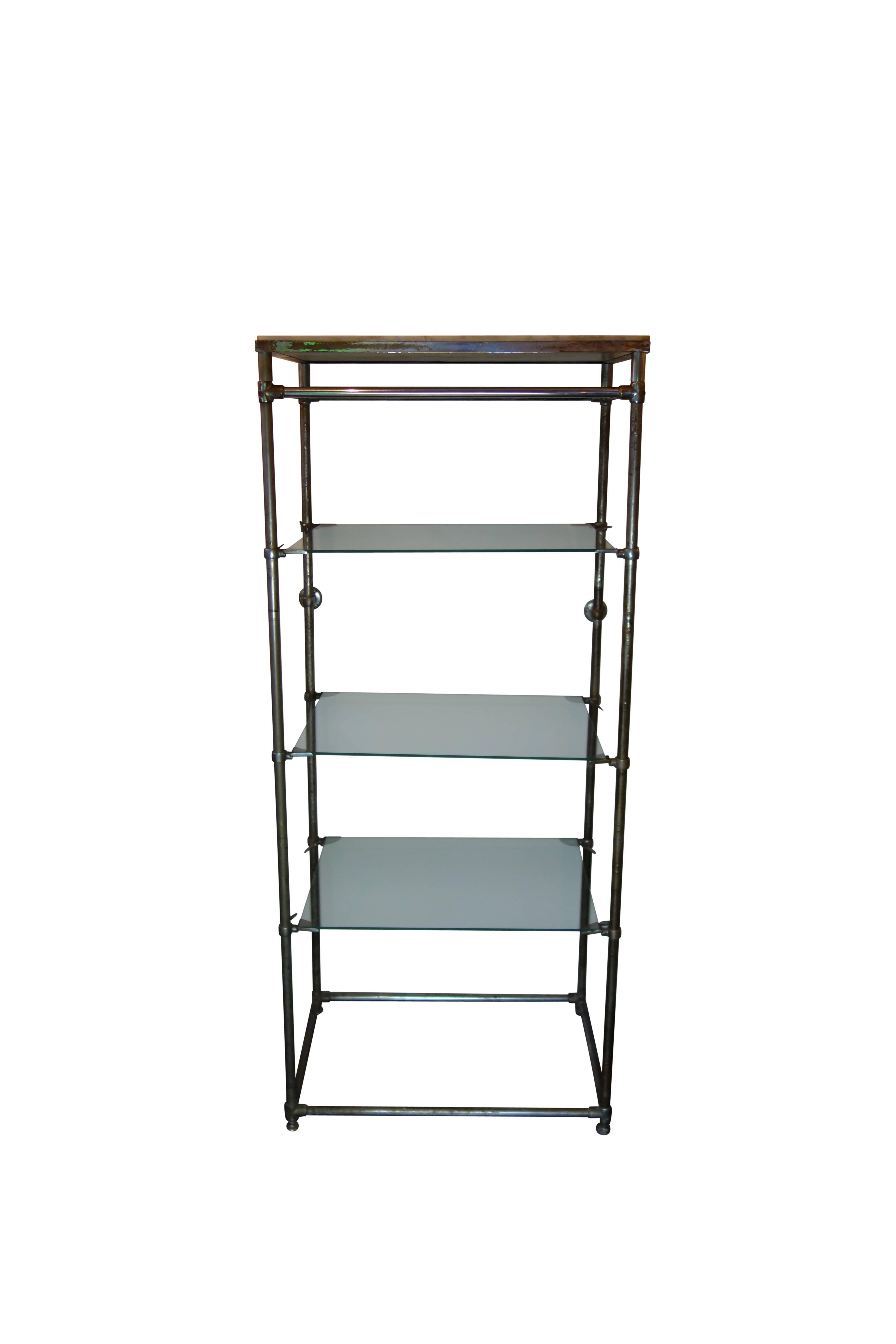 This is an Industrial style shelf with nickel plated brass frame, adjustable glass shelves, and marble top. Mounting hardware on the backside of the frame allows you to secure the piece to the wall. On the back is a label, made by Industria