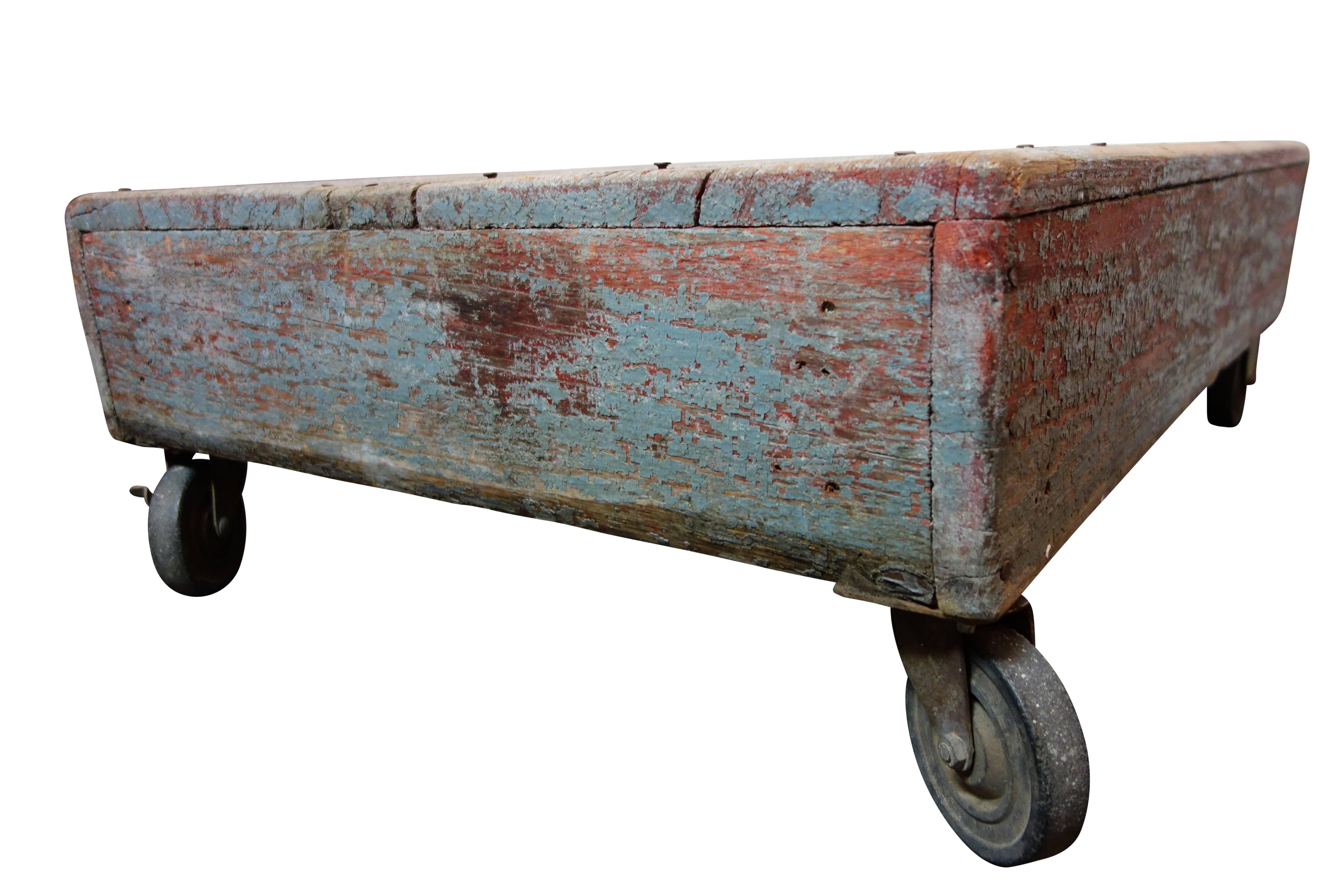 This is a gray and red painted wood industrial cart on casters from Texas.