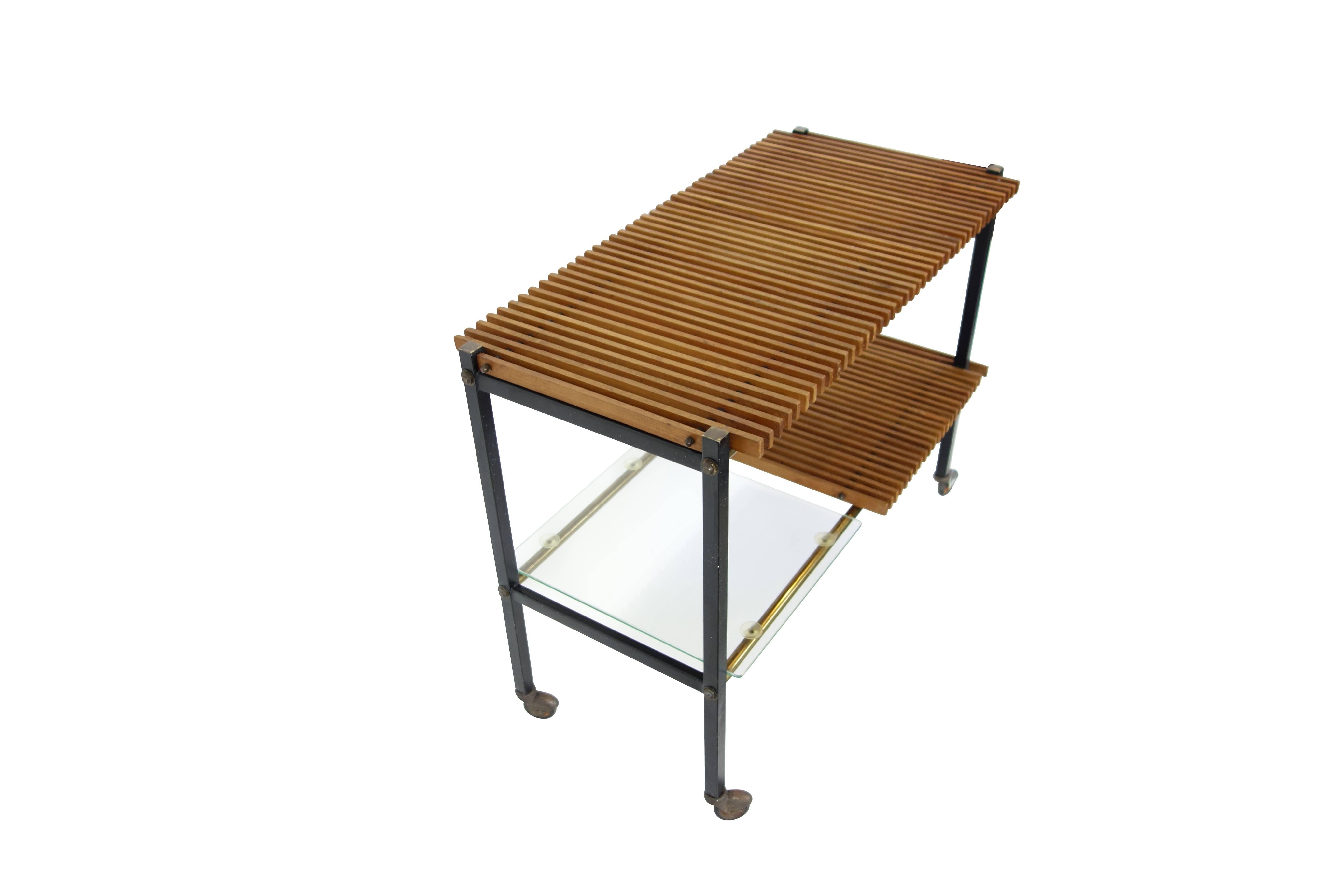 This is a sleek midcentury Italian console table with a slat wood top on casters. The bottom shelf is half slat wood and half glass. The glass portion is held to the frame with four small suction cups.