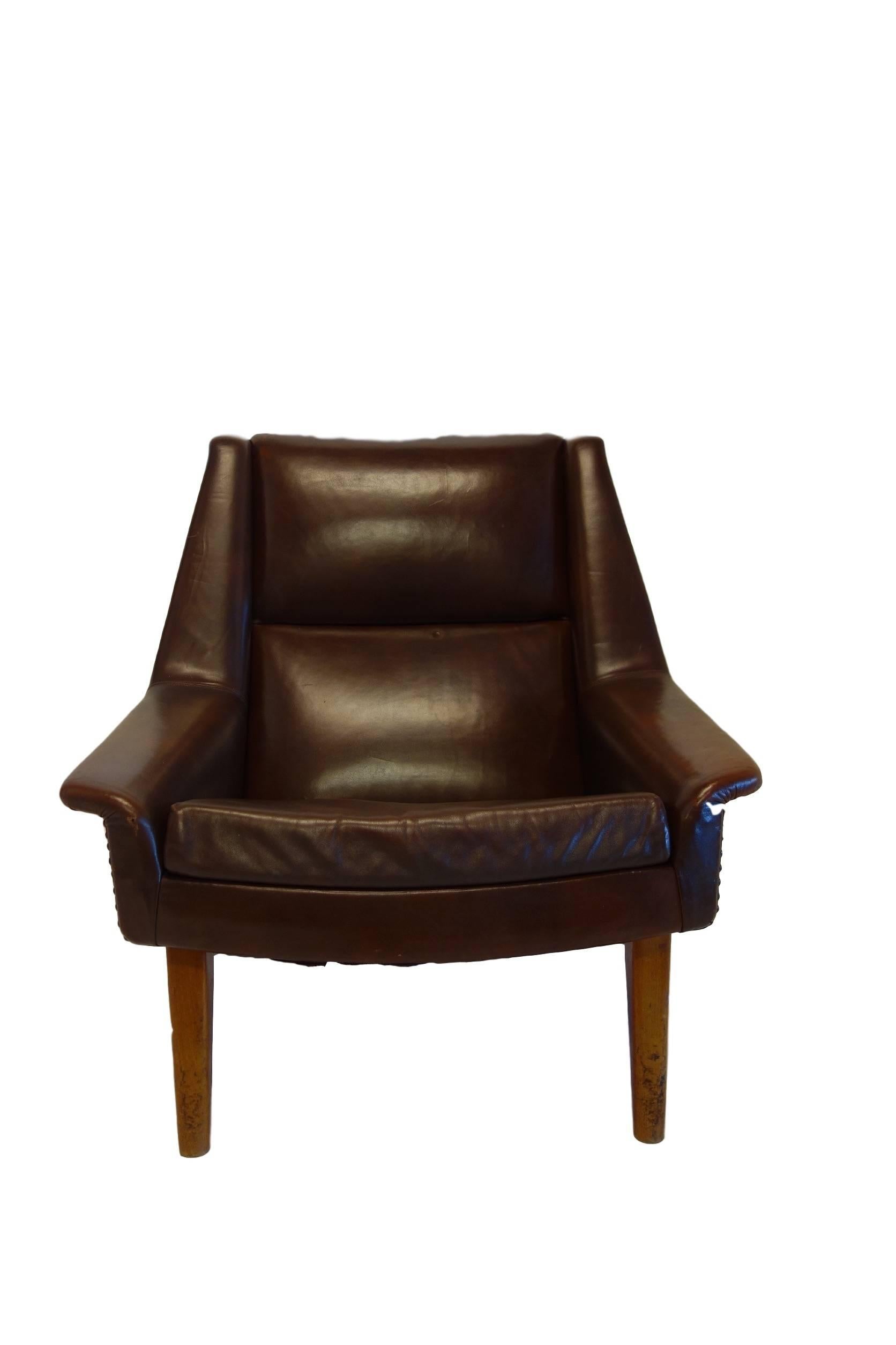 This is a handsome Danish Mid-Century Modern Folke Ohlsson chair in it's original brown leather upholstery. With it's deep seat and sleek lines this vintage chair is not only comfortable but attractive as well. The frame on the underside of the