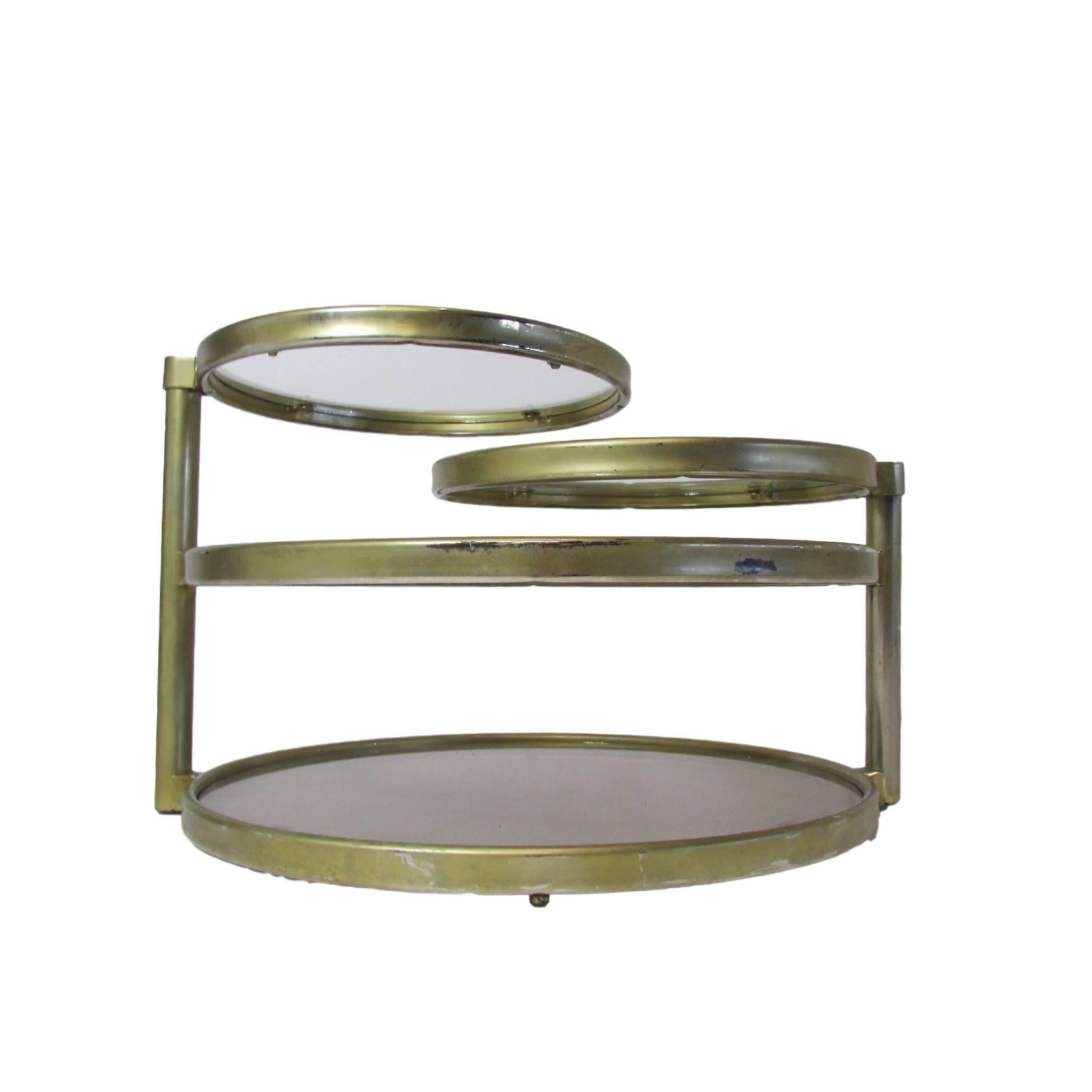This is a circular four tier articulating glass and steel coffee table in the style of Milo Baughman. The piece of glass in the bottom tier is smoked.  The two top tiers rotate 360 degrees making this piece quite versatile.  