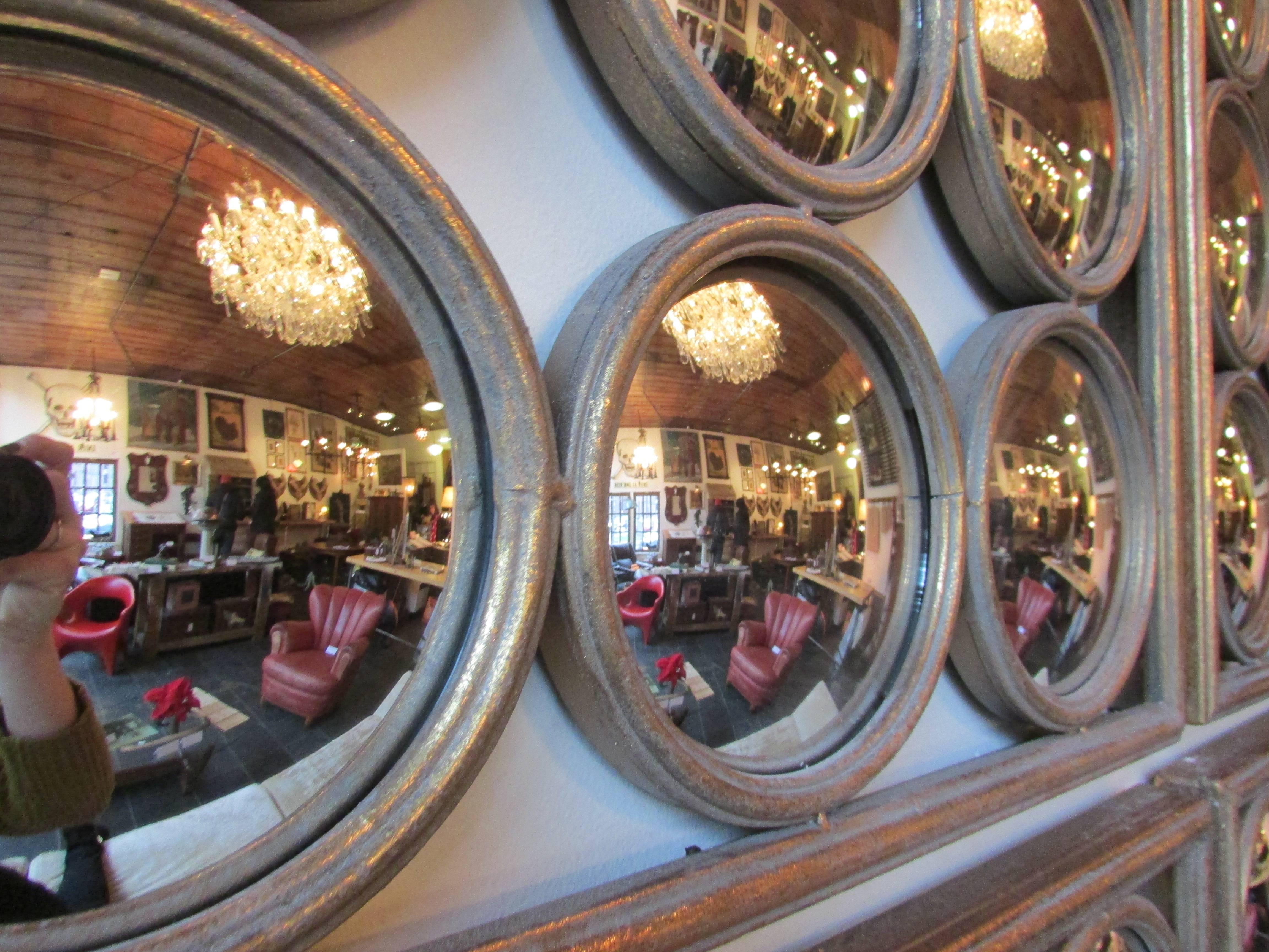 This is a 36 lens convex mirror in a gold painted steel frame that came out of a hotel in Paris. This unique mirror makes a bold statement on its own or an even more dramatic statement when grouped together.