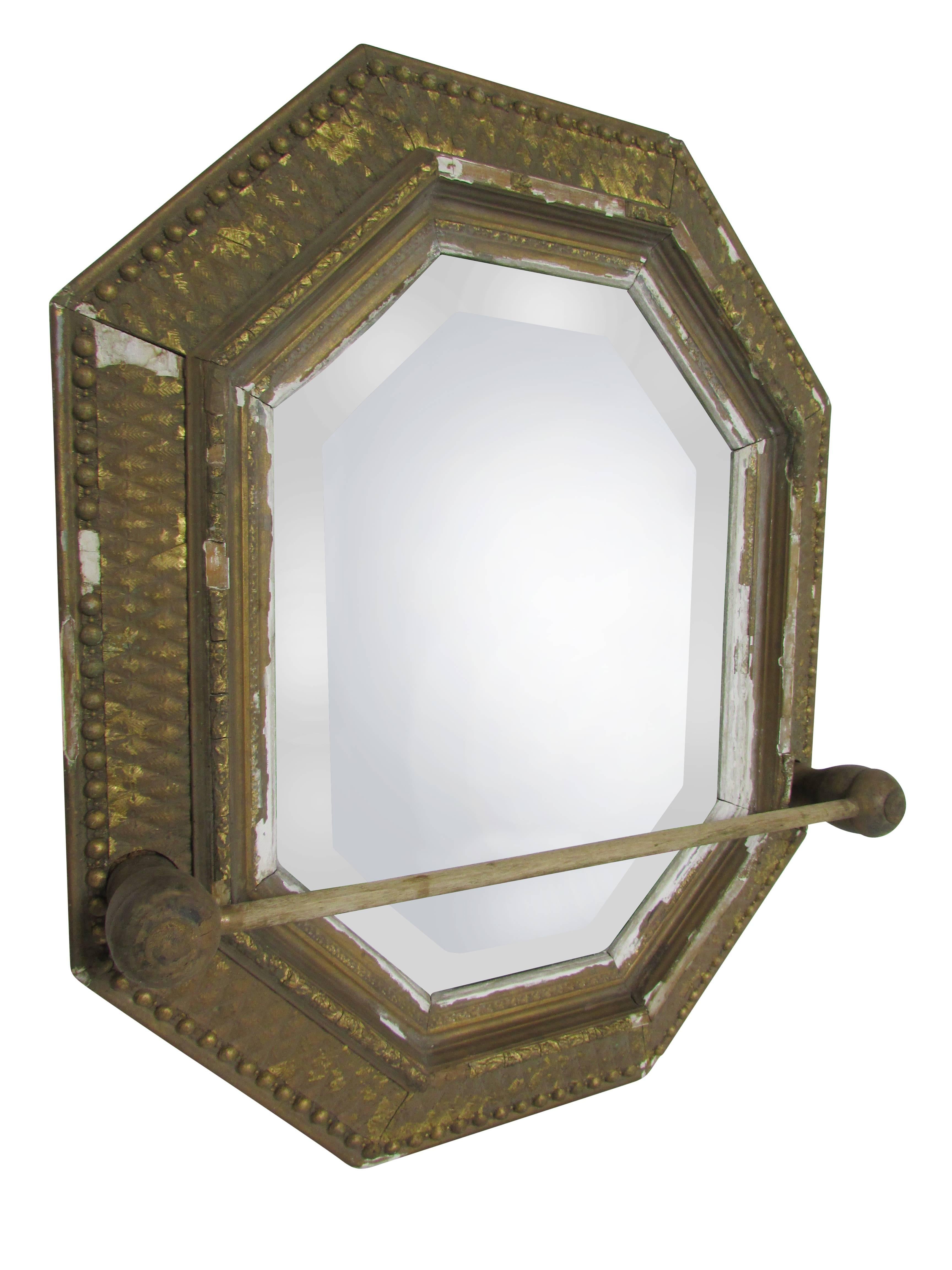 This is an early gilt frame mirror with wood bead trim and hand-carved details. With it's original beveled glass and unique towel bar, this mirror is the perfect addition to a powder room.