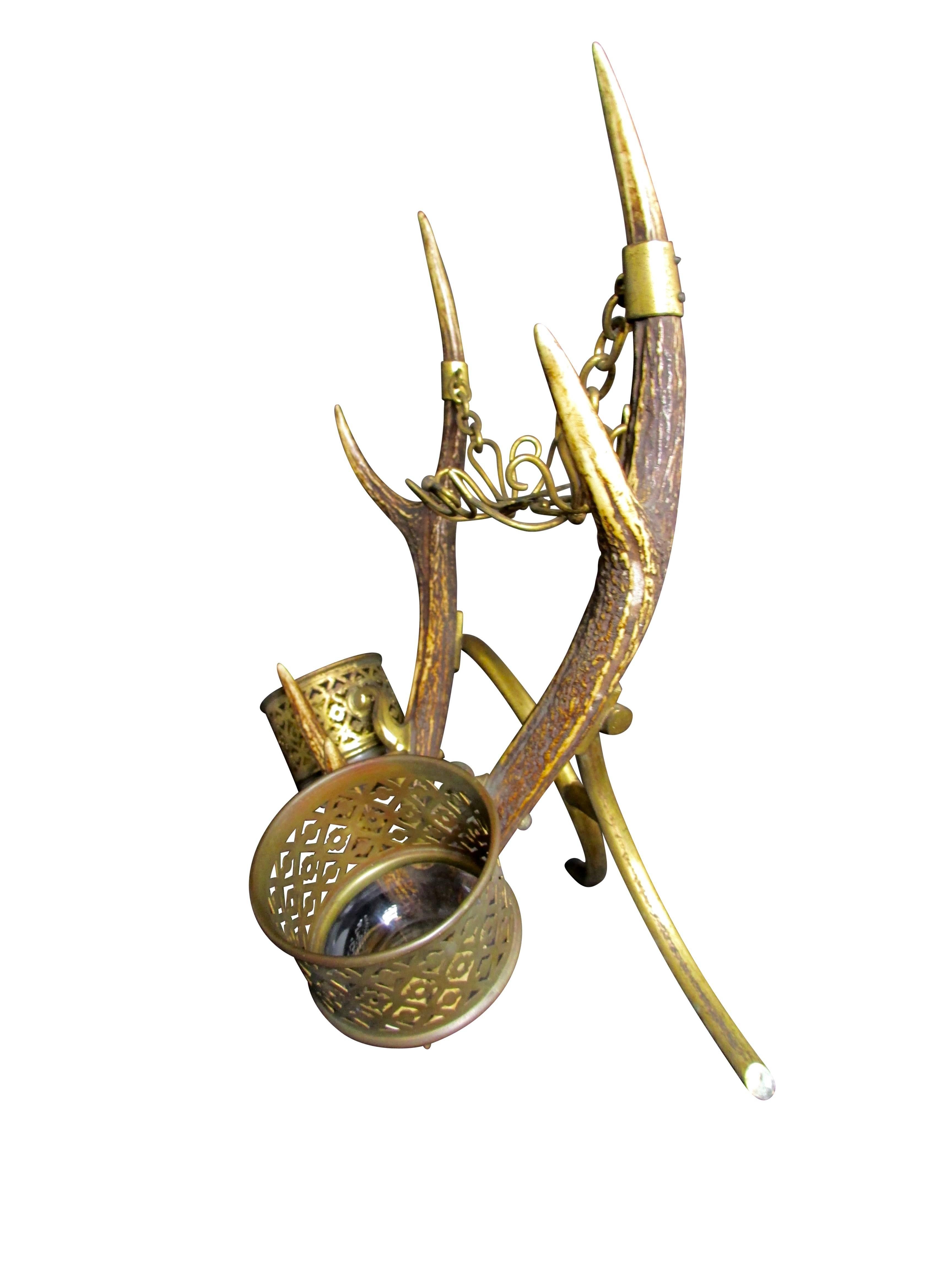 This is a one of a kind shaving stand made of deer antlers, brass, and glass. Mounted on each horn are glass cups with lovely brass detail. Suspended on chain between the two horns is a cradle to hold a bar of soap. At the base of the stand is a