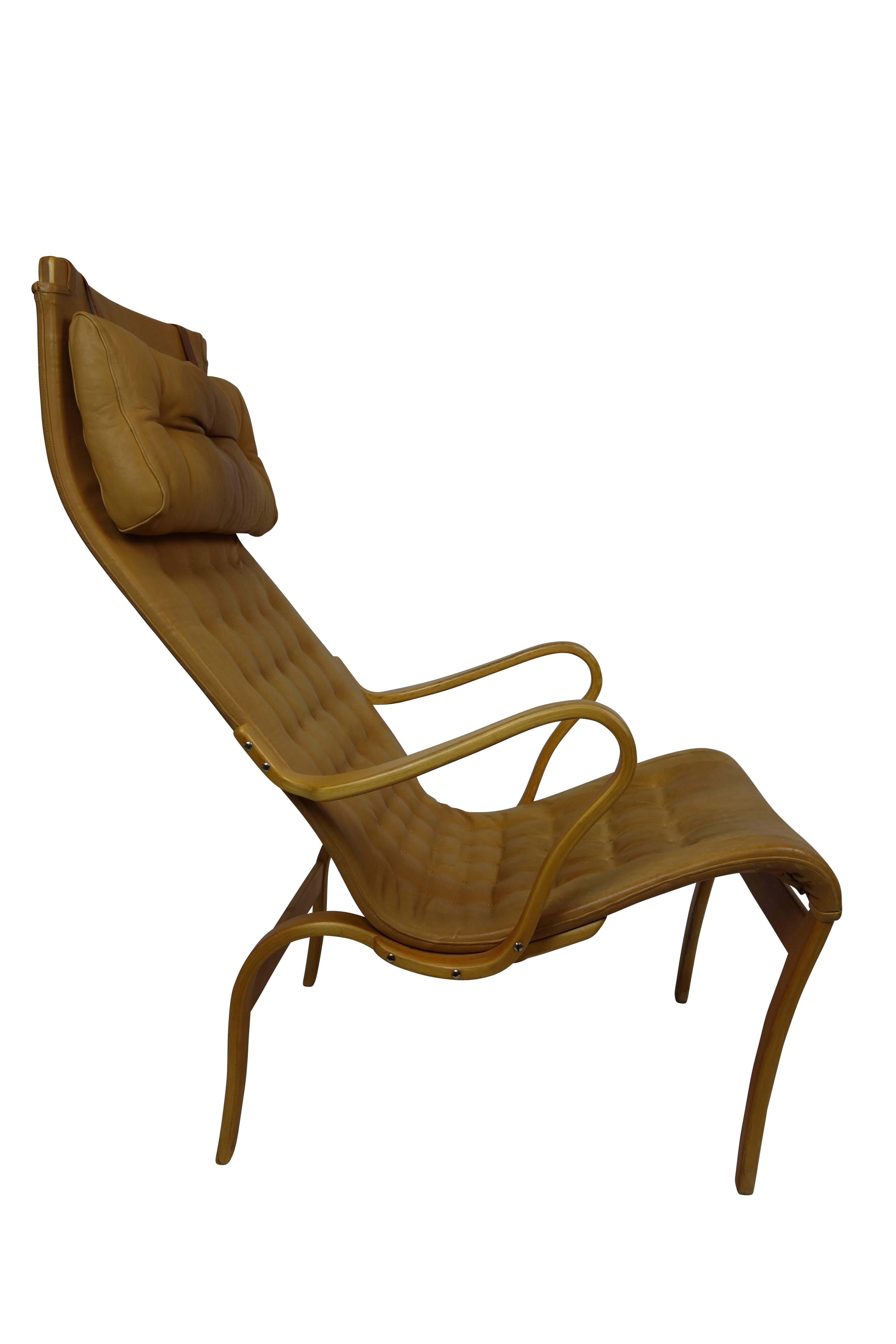 This is a sleek midcentury Miranda lounge chair by Bruno Mathsson in lamented bent birchwood in its original tan leather upholstery circa 1960.  