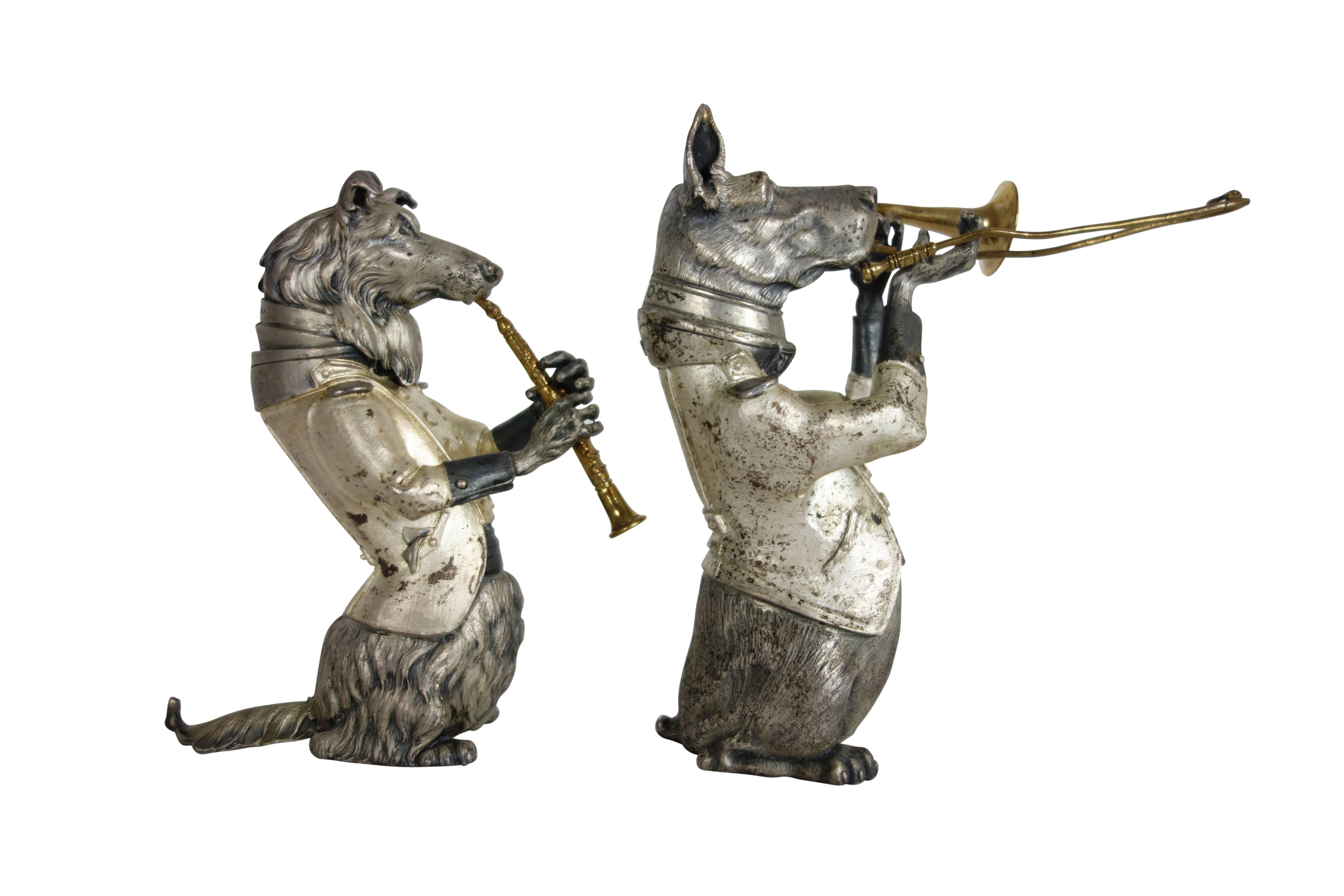This is a fantastic pair of instrument playing dogs made of pewter, nickel, and brass. Their names are written on each of their collars, "Dogo" and "Collie." The taller dog playing the trombone is named "Dogo" and