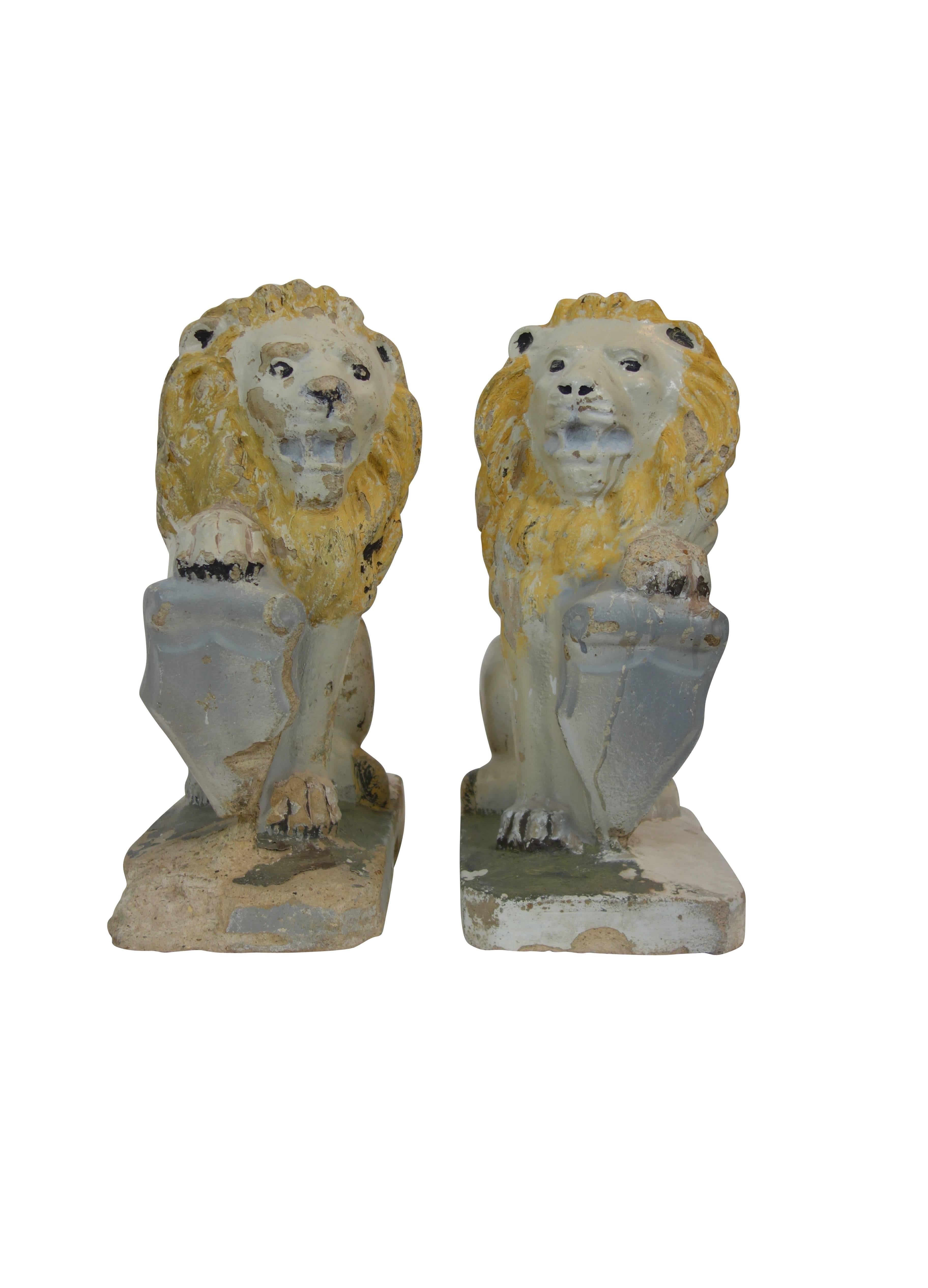 Pair of painted concrete garden lion statues with shields, in “Sejant-Rampant” pose.
 