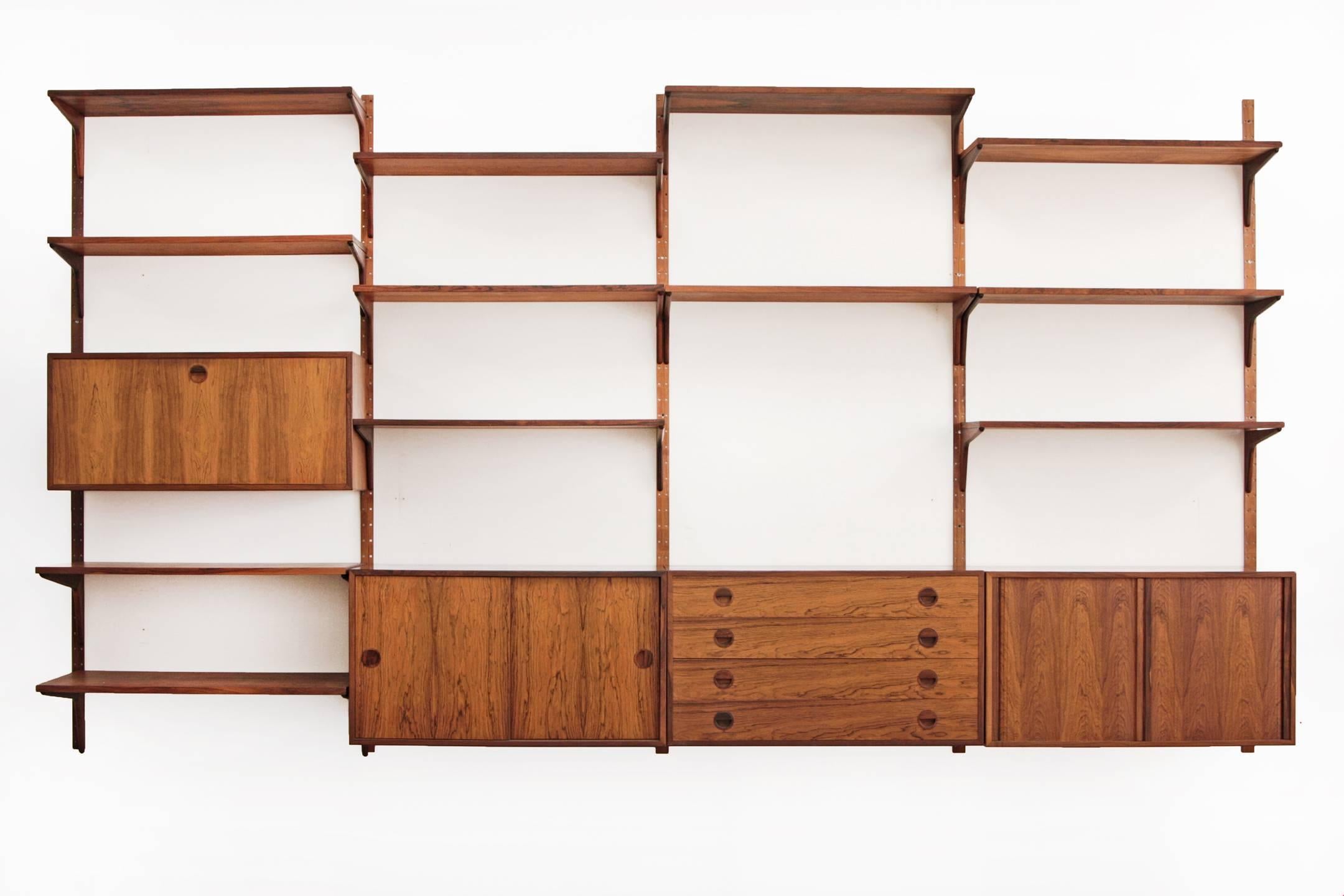 Rosewood Danish modern modular wall unit by Hansen and Guldborg. Five rails suspend a four bay unit consisting of four cabinets and 12 shelves. This unit is completely modular and can be configured however suits your needs.
