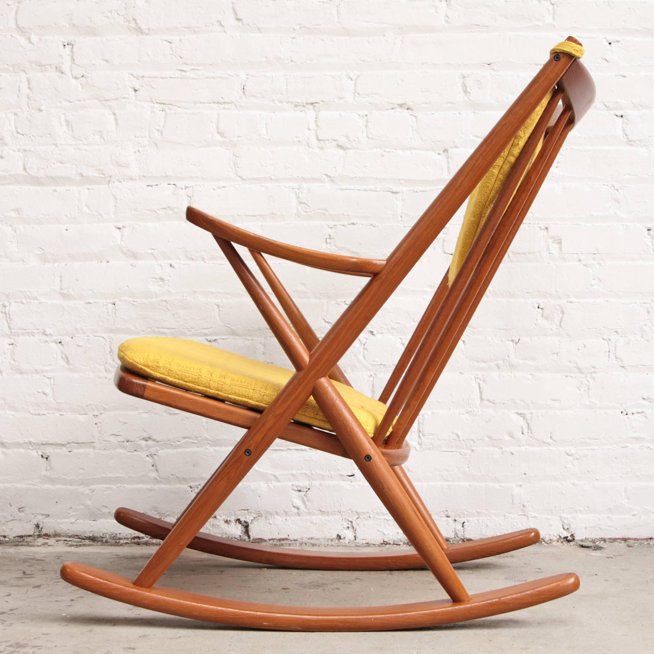 Solid teak rocking chair designed by Frank Reenskaug for Bramin Mobler in 1958, made in Denmark. Newly upholstered yellow cushions.
 