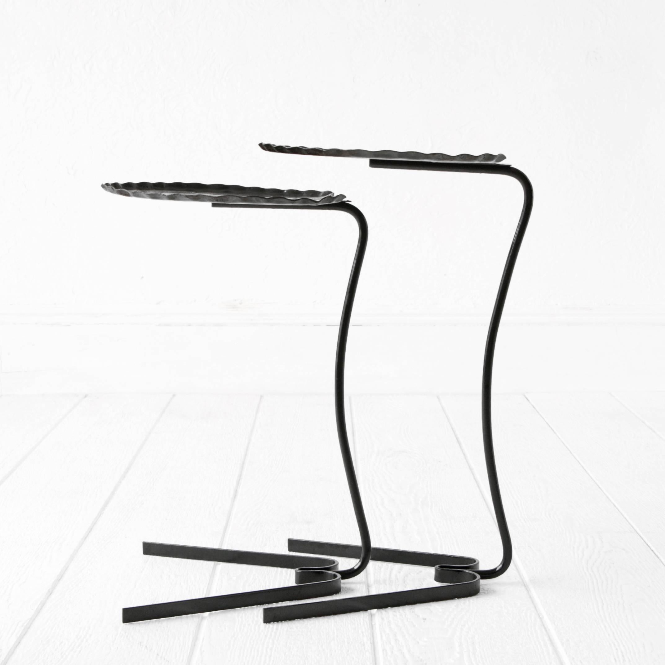 Two wrought iron metal lily pad cantilever tables designed by John Salterini. One is larger that the other and they nest together.

Large: 13.5