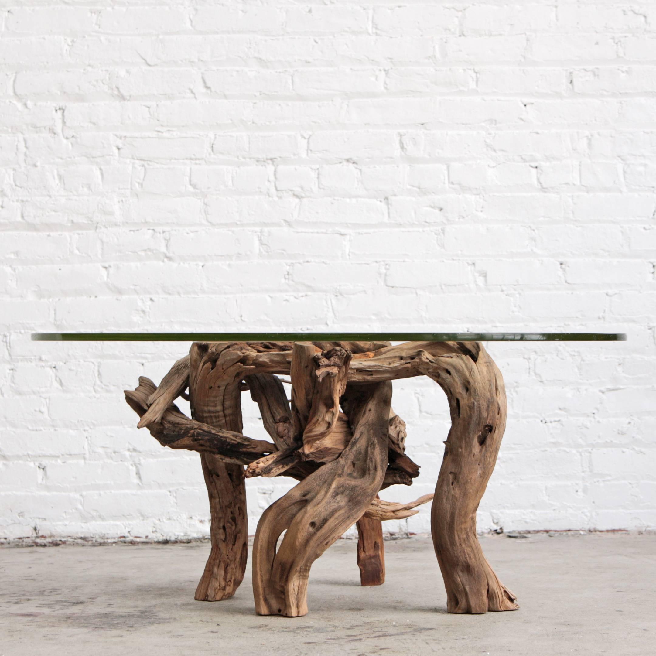 Glass tabletop suspended by a natural driftwood base. free-form organic shape with a modern feel.