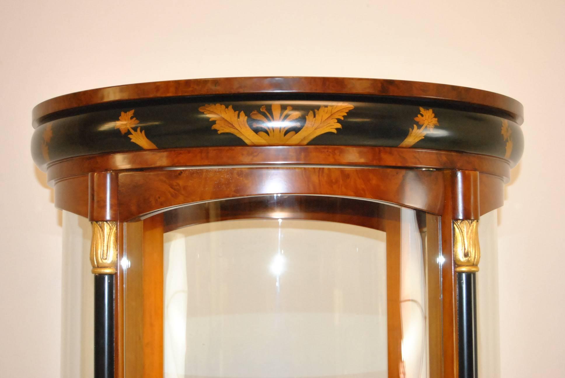 Beautiful Biedermeier style curved glass lighted curio cabinet. Three glass adjustable interior shelves. Black painted highlights with decorative gold designs Very nice pre owned condition. No damage. ap17223.