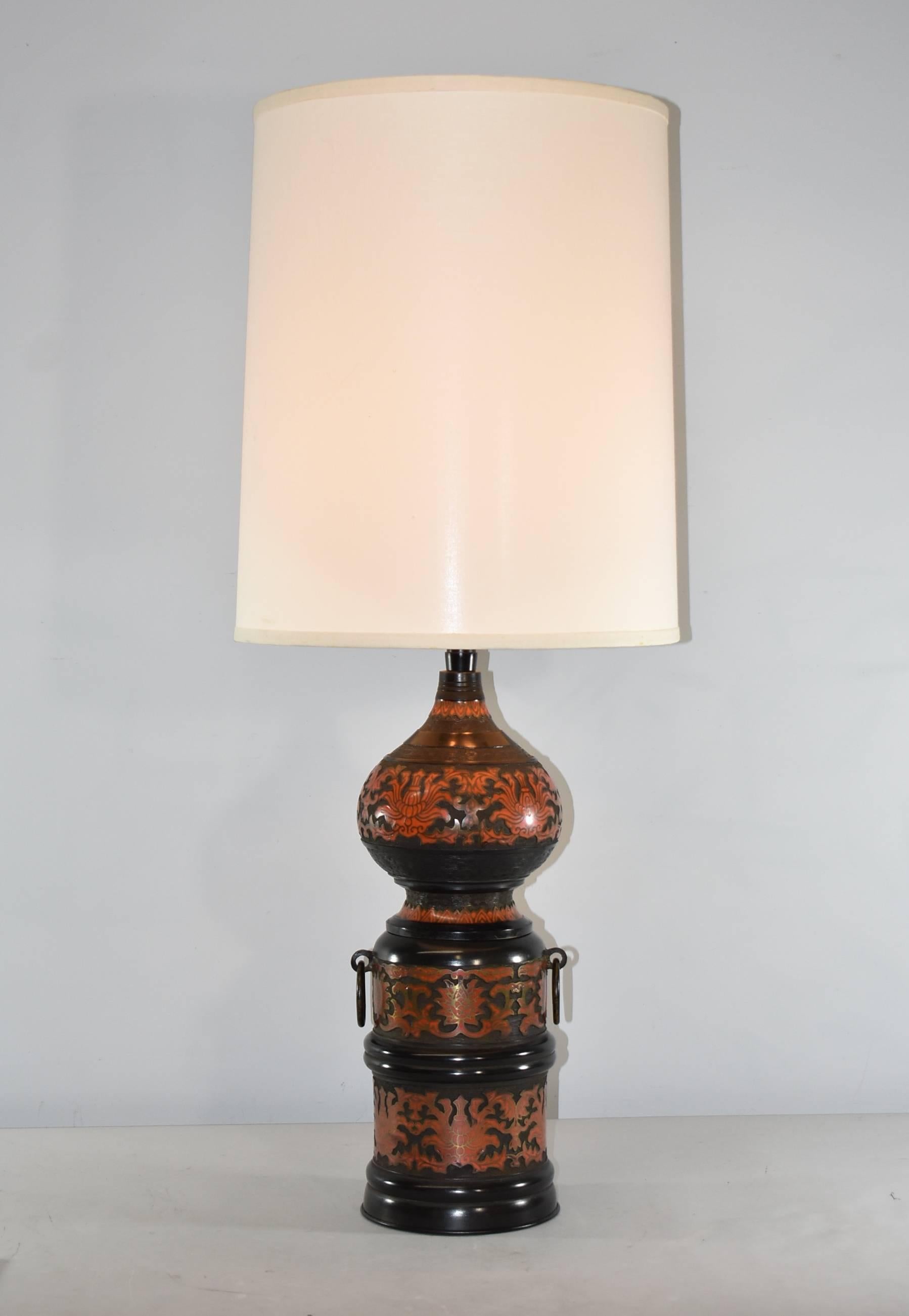 Champlevé cloisonné enamel table lamp by Marbro. Black field with intricate patterns in Chinese red and two applied decorative ring handles. Two sockets
have independent pull chains and an additional switch on the cord. One ball on pull chain has