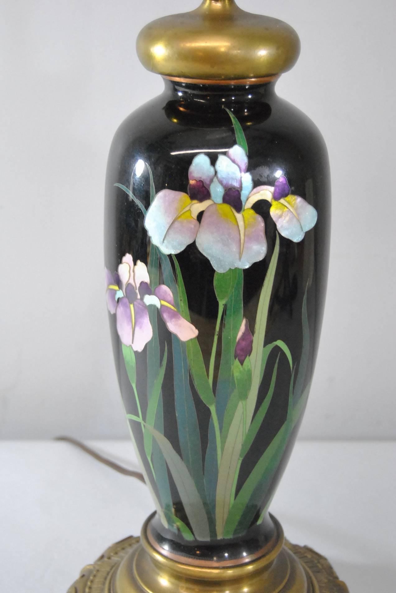 A beautiful Japanese Meiji cloisonné table lamp. It features an enamel finish with a black field and purple, blue and pink iridescent iris flowers. The shade shown in the photo is not included. 26 3/4