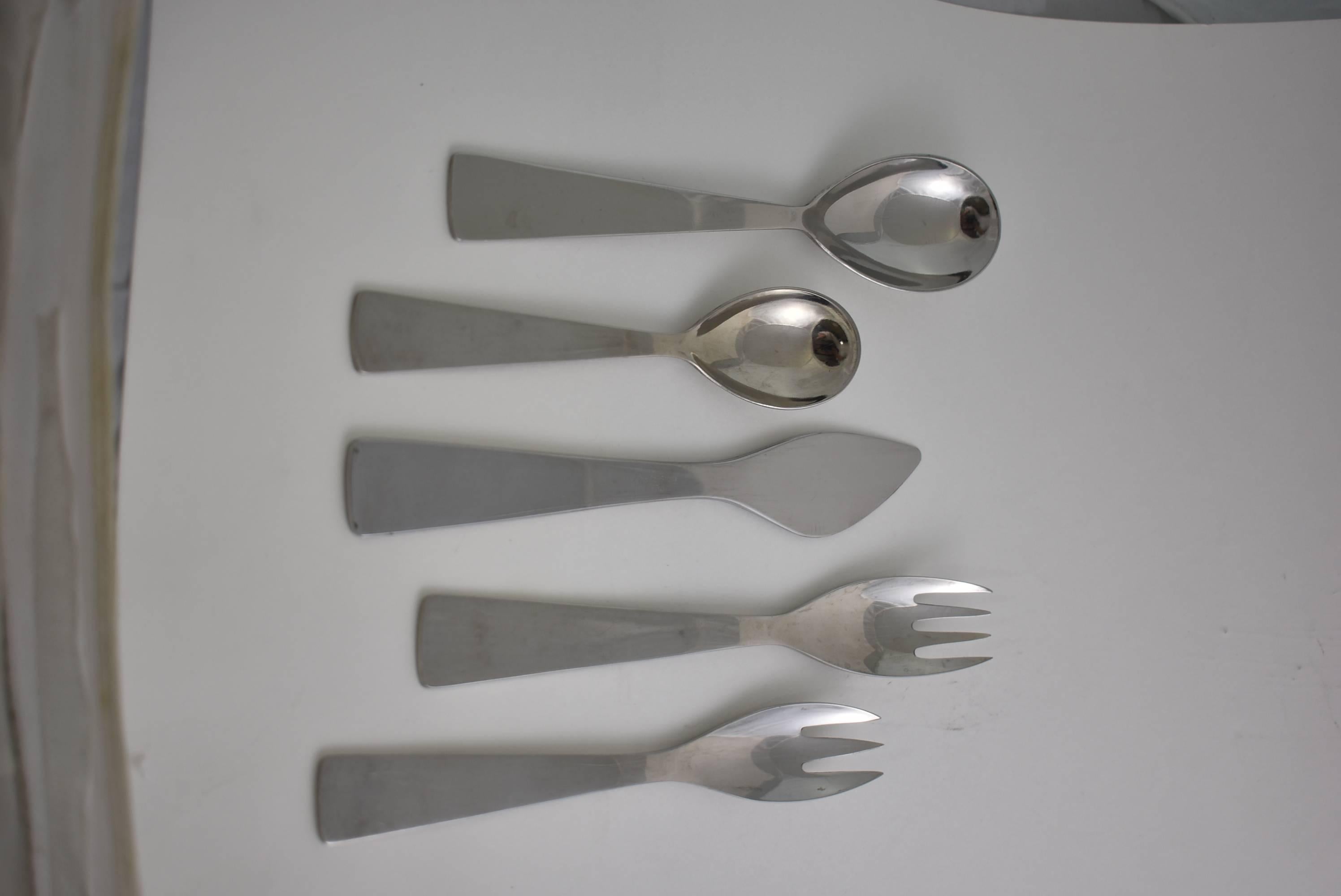 Mid-Century Modern stainless flatware, circa 1950s by Gio Ponti for Fraser Krupp. Made in Italy. Twelve place settings consisting of two forks, two spoons and a knife. Overall light wear from age and use. Large spoon 7