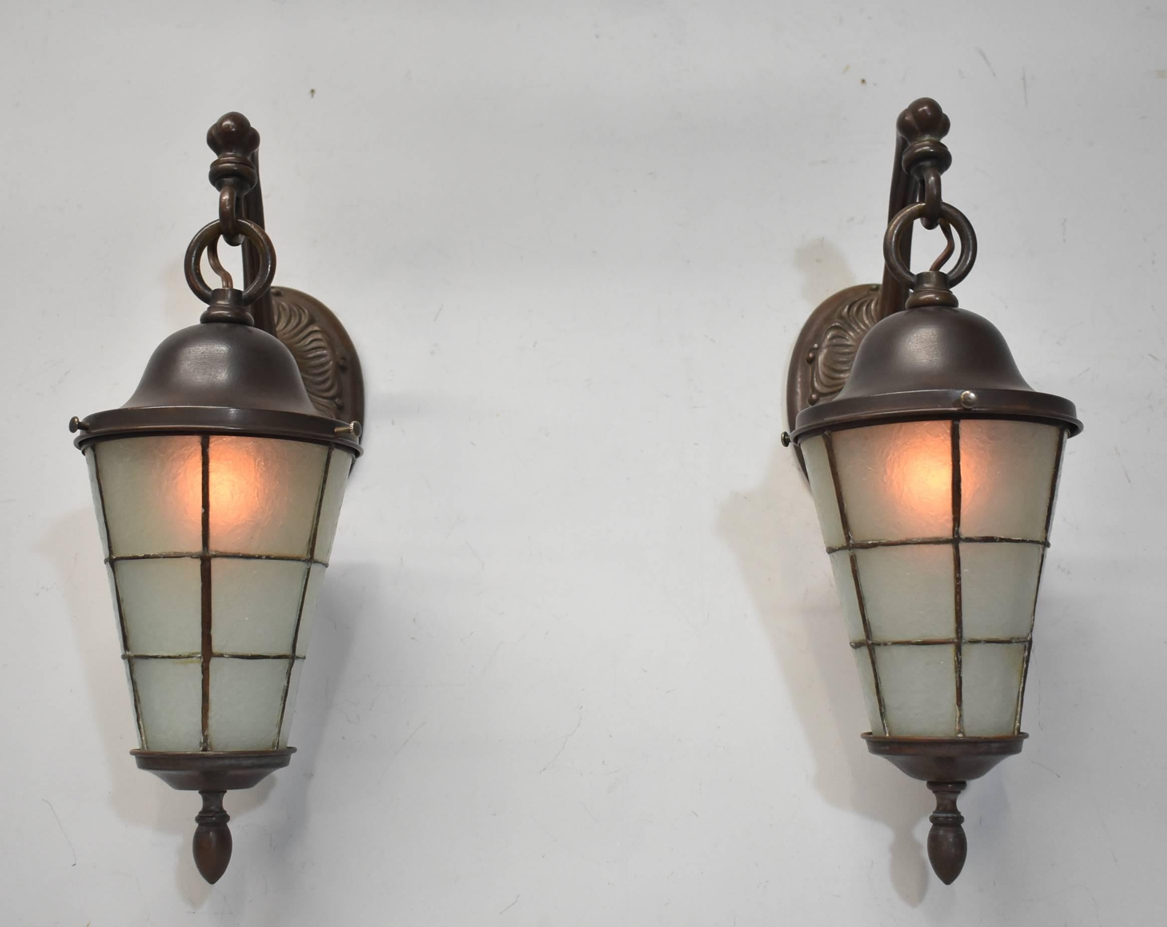 Antique pair of Handel Tudor style heavy cast bronze and bent leaded glass wall sconces. Can be used interior or in an exterior application. New wiring. Stamped Handel. Single socket. Measures: 14