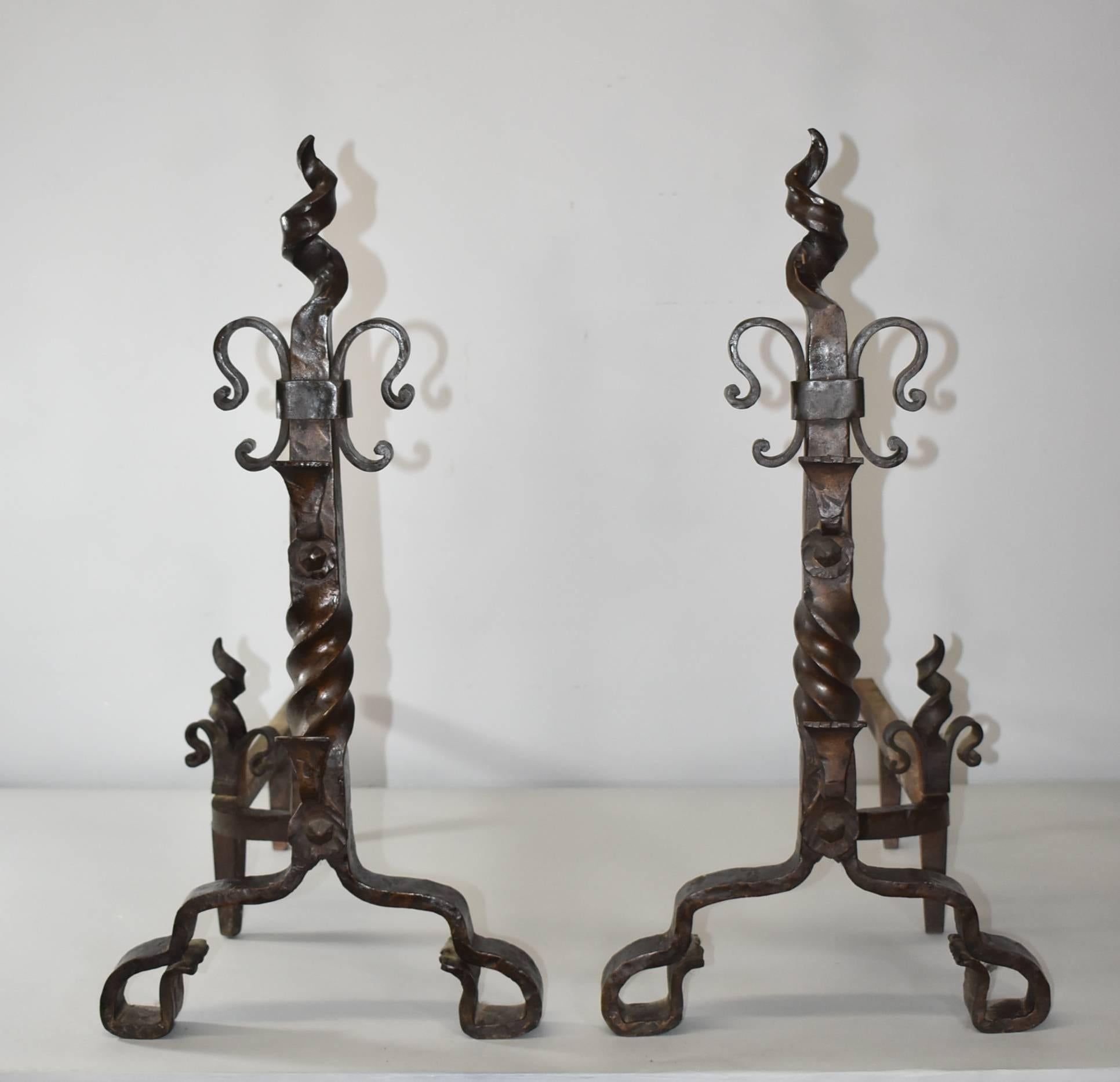 A handsome pair of Gothic revival hammered forged iron andirons that are attributed to Samuel Yellen. Very sturdy these andirons feature a twisted top and centre column. The dimensions are 26
