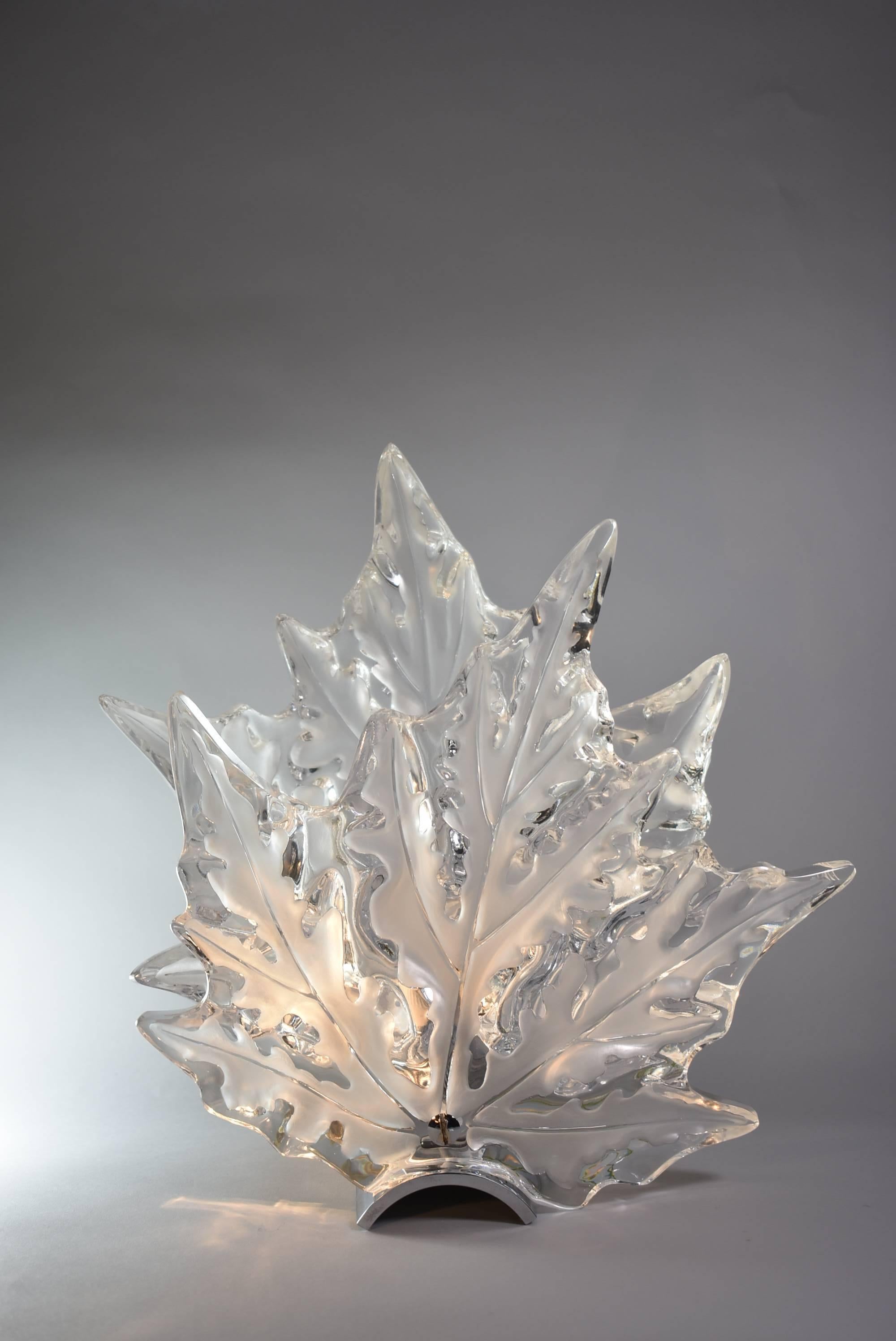 An exquisite pair of crystal and chromed brass wall sconces. They feature a beautiful leaf form. Simply stunning. The measure 12