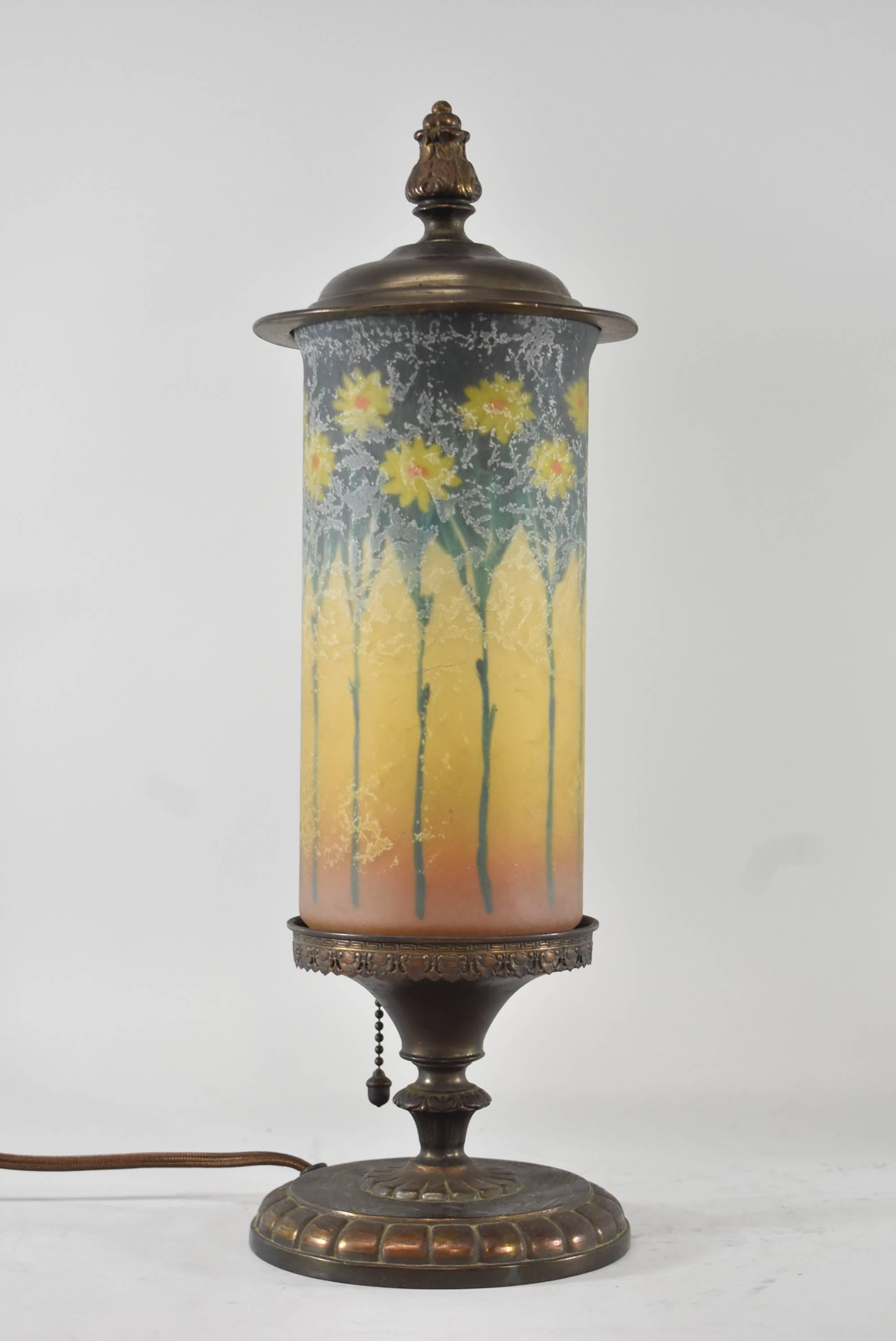A beautiful pair of reverse painted mantel lamps by Handel. The shades feature alternating tall and short flowers, yellow with an orange center and a textured finish. They are signed Handel 699AC.