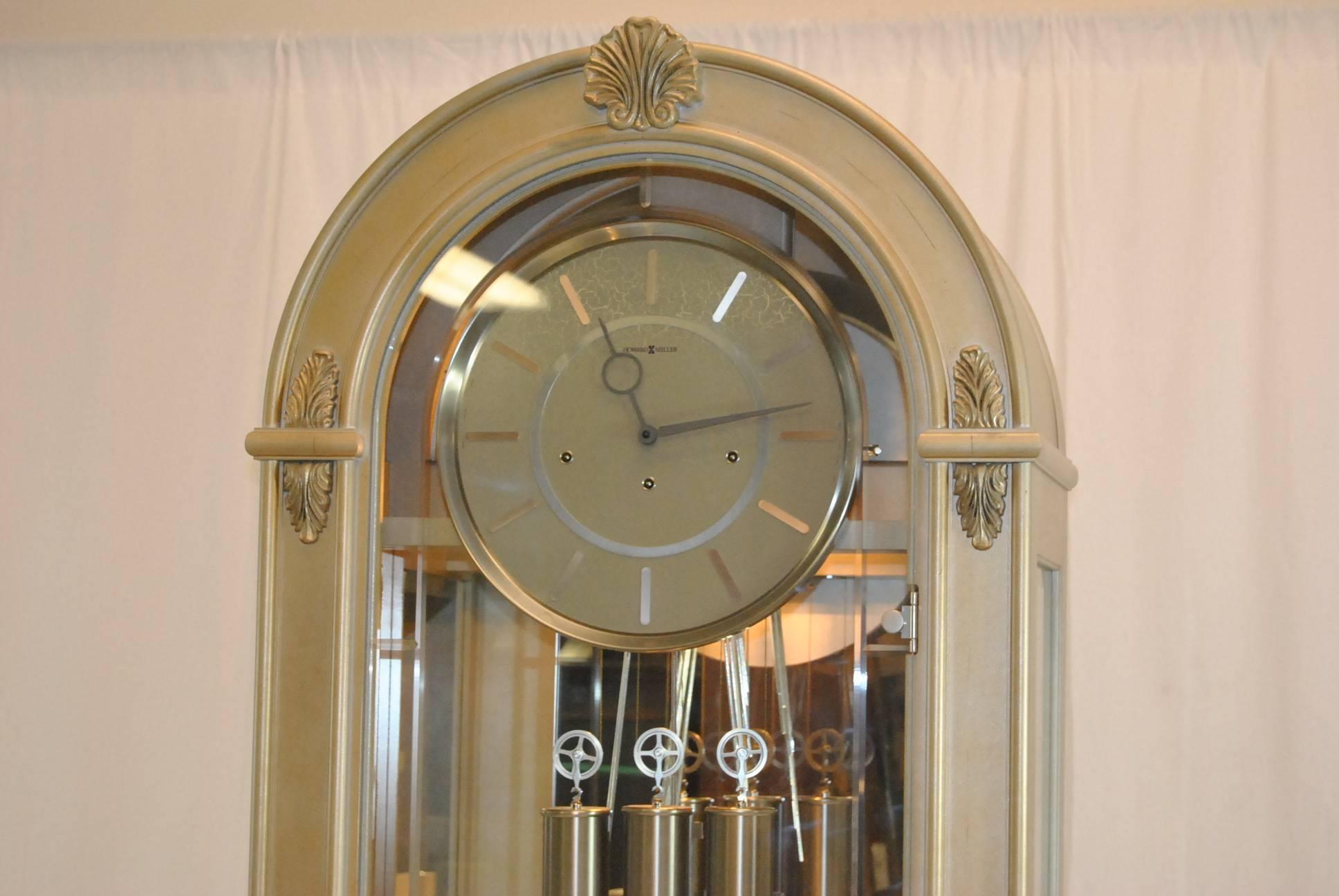 A great contemporary grandfather clock by Howard Miller.  This is the Coastal Point Model 610-898 which was designed by Chris Bergelin and has been discontinued. It features a platinum finish on hardwoods and veneers on the arched case with