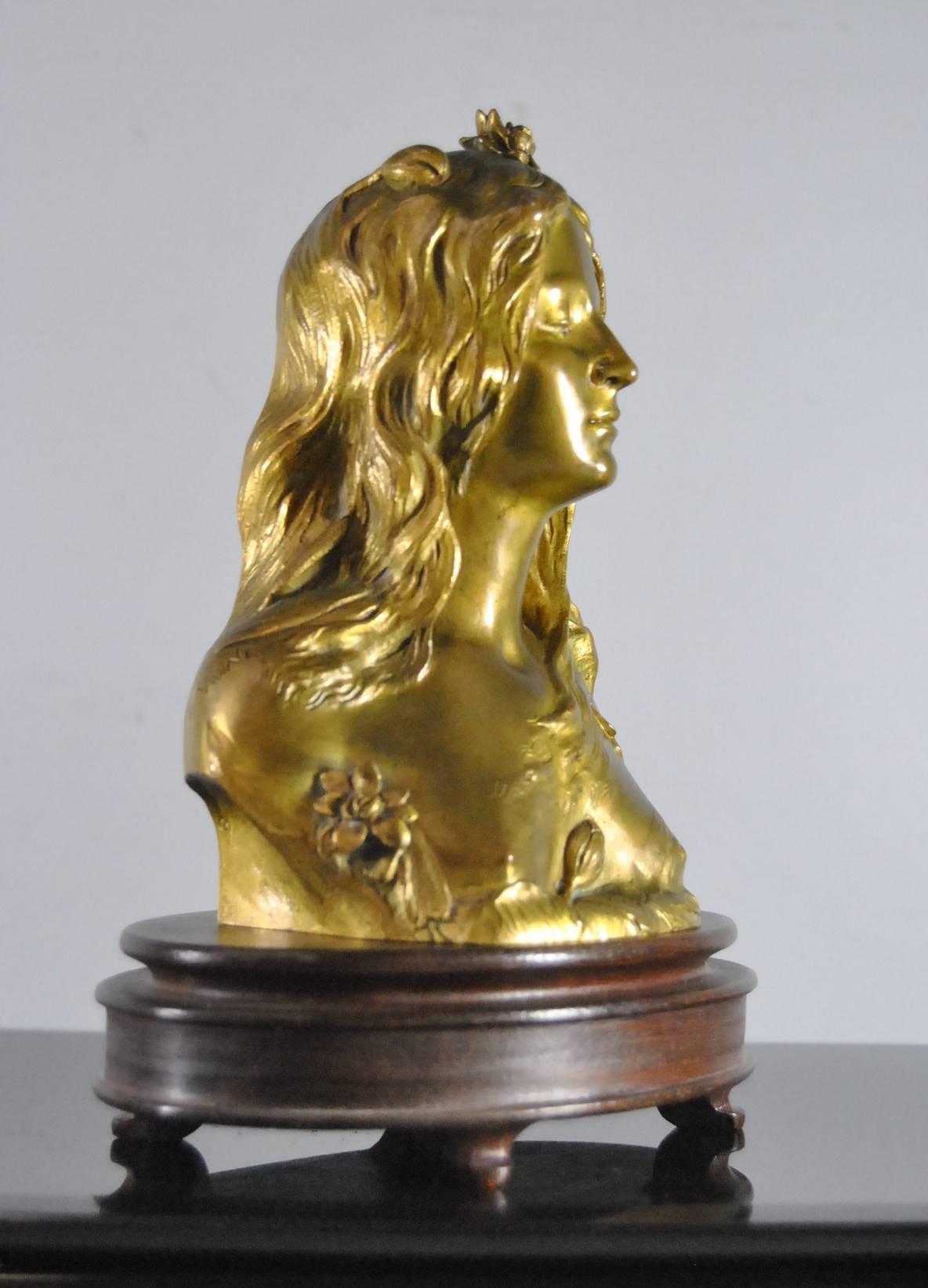 An Art Nouvea Gilt Bronze Bust of Ophelia by Leopold Savine (1861-1934).  A beautiful bust with the back depicting water and trees by which she met her demise.  Signed L. Savine in the bronze.  Bust sits on oval wood base.  