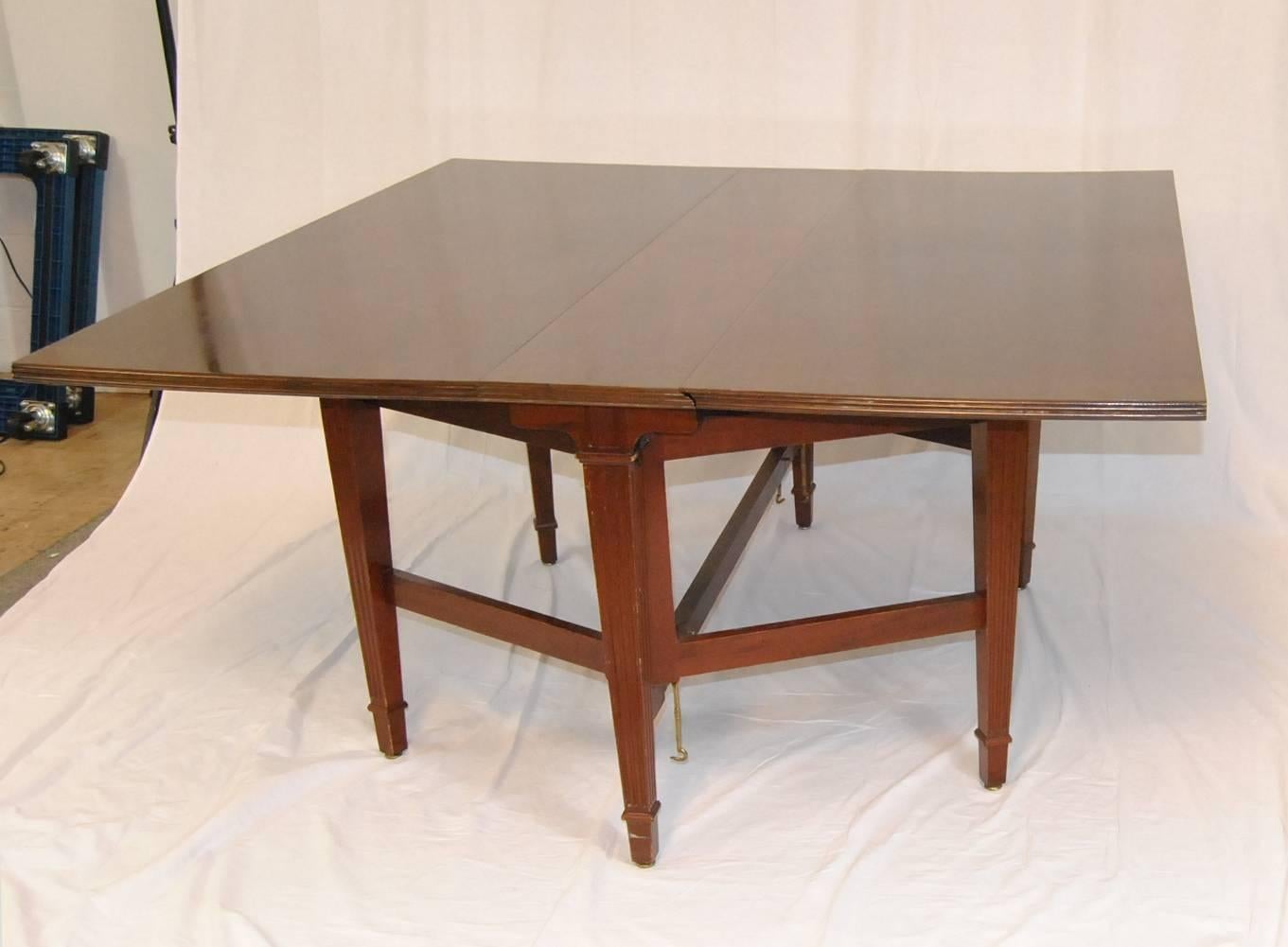 An unusual 25 ft mahogany conference table by Irving & Casson / A. H. Davenport Company.  This conference table is comprised of 5 gateleg drop leaf tables with solid brass connecting hardware.  Each table has a banded top with center done in a