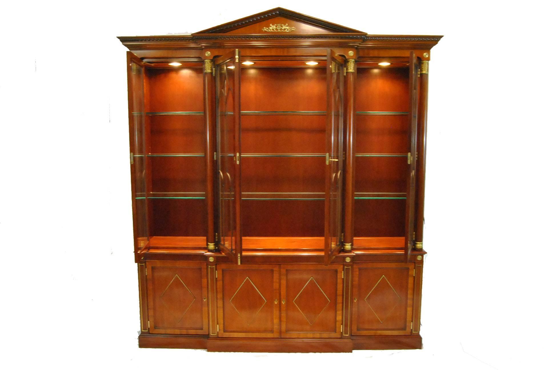 Neoclassic Mahogany Breakfront with crown molding inset with a carved egg and dart molding; Four half-rould columns are topped by hand carved capitals.
4 glass paneled doors over four diamond patterned doors; omolu mounts,rosettes and escutcheons