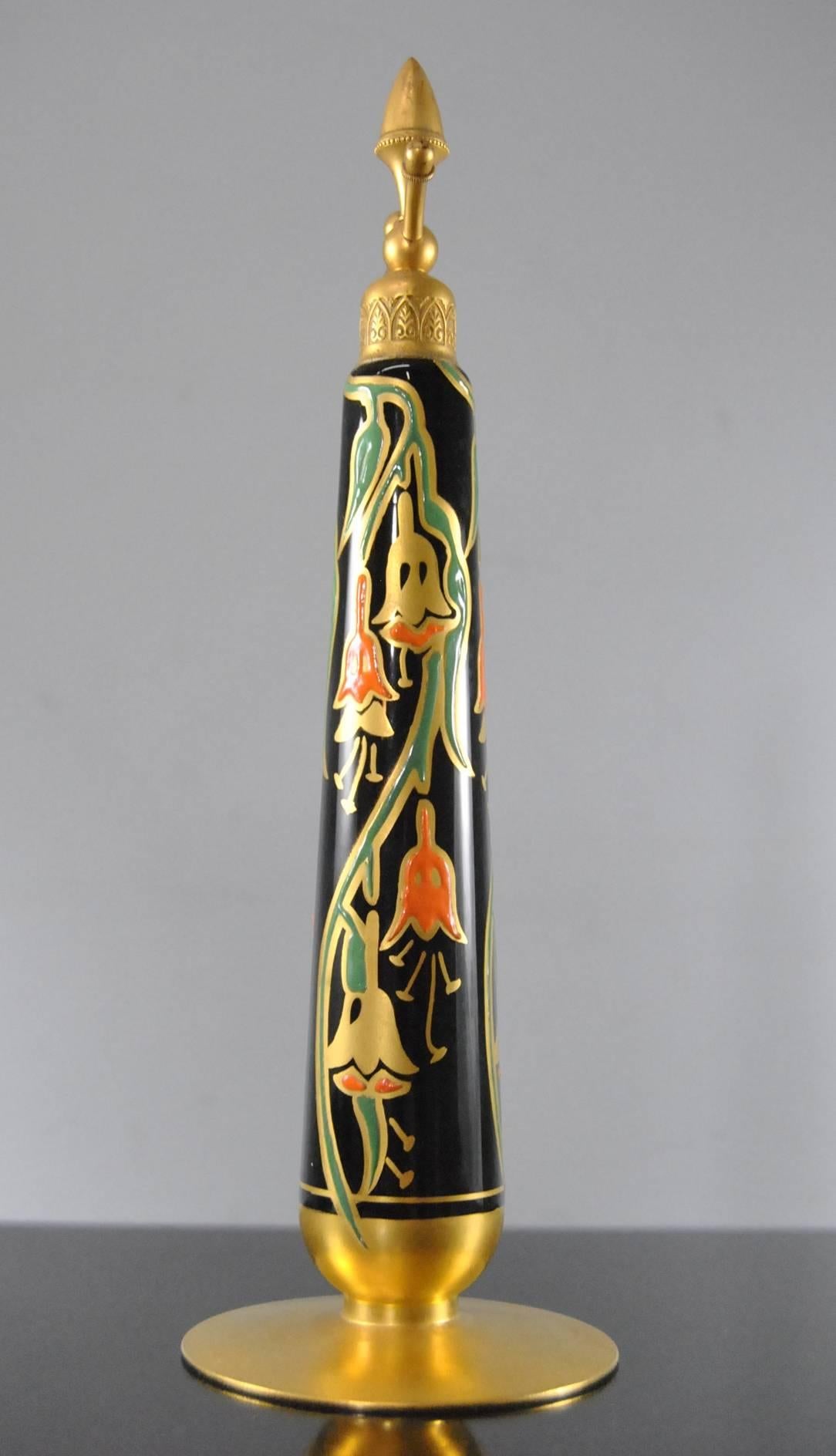 An Art Deco style atomizer perfume bottle by DeVilbiss.  This beautiful bottle features a black body with gold, orange and green enameled stylized flowers and a small acorn finial on top.  This is a beautiful statuesque bottle.  The atomizer bulb is