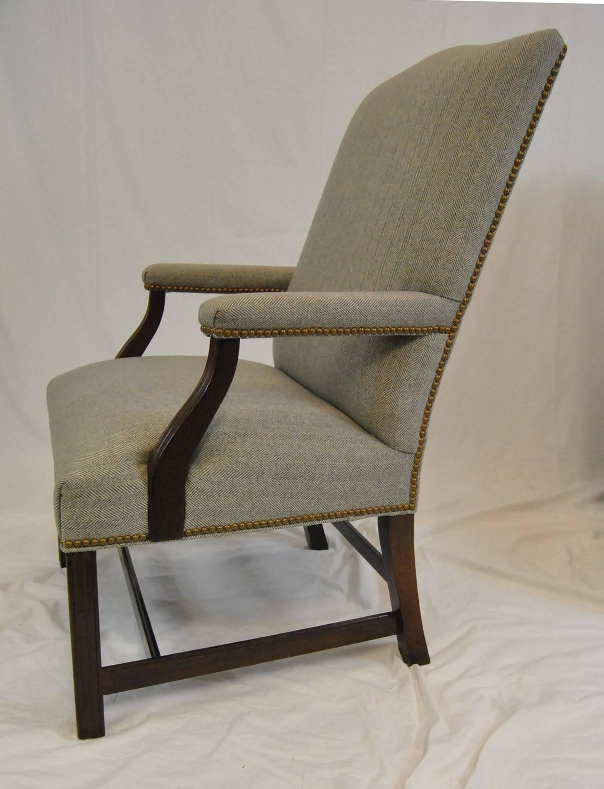 A great pair of Martha Washington style armchairs by Hancock & Moore. This pair has mahogany frames with stretchers for added strength. They are upholstered in a herringbone fabric with nailhead trim. Hancock & Moore tag is on the bottom of chair.
