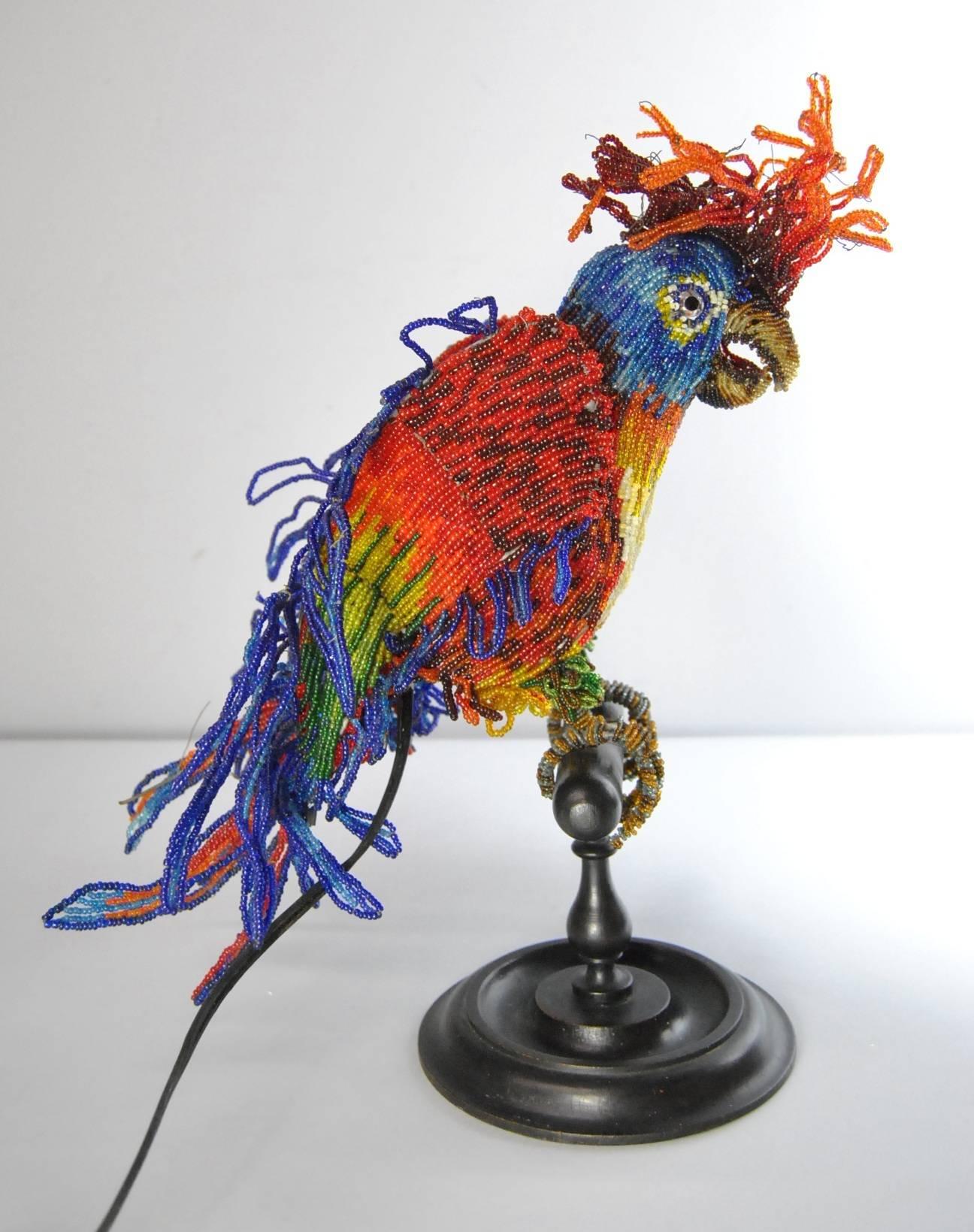 A rare antique beaded parrot bird lamp. A beautiful beaded parrot perched on a turned wood base. This unusual lamp has vivid colors and beautiful glass eyes. A real treasure. It is in good condition though there are some missing beads. The