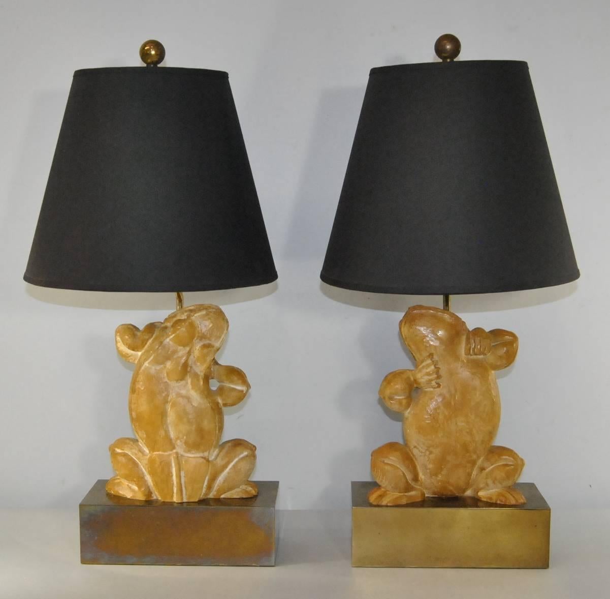 Pair of Chapman dancing frogs table lamps. Stylized composition frogs are made to resemble carved wood atop a rectangular brass base. There is some oxidation on the bases. Good wiring. Marked Chapman on the socket. Measures: Frogs are 9 1/2