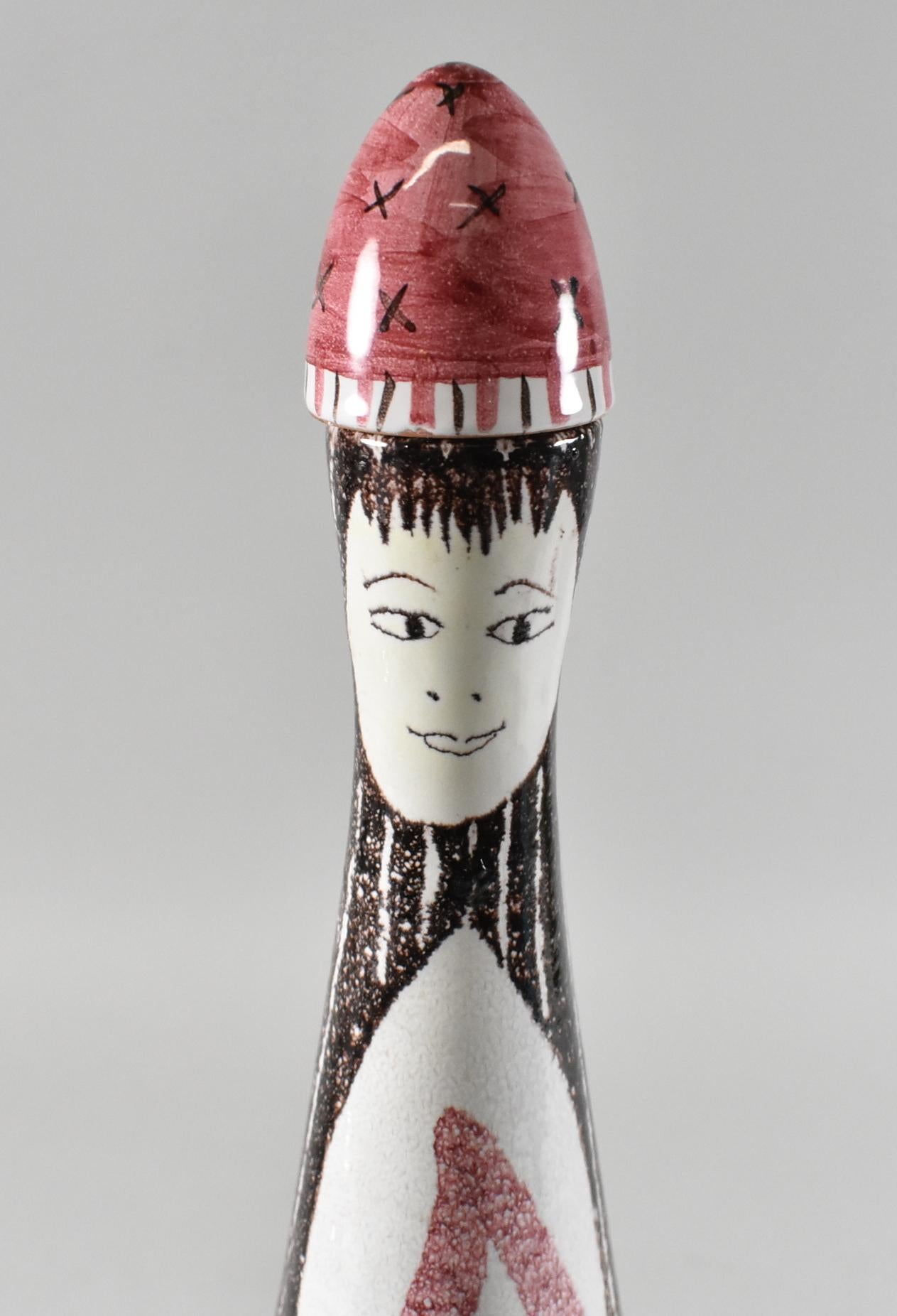 Service à saké en céramique d'Aldo Londi pour Bitossi, vers 1950-60. La carafe représente une femme ou une reine stylisée, vêtue d'une robe ou d'un manteau rose, et est munie d'un bouchon en liège. Chaque tasse présente un visage unique. Marqué