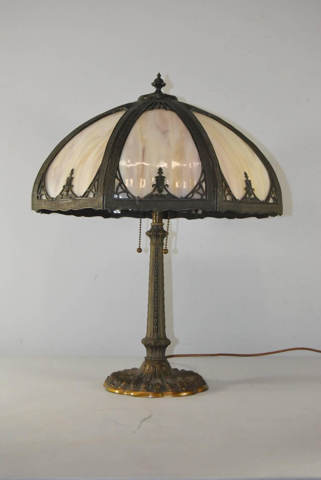 A nice eight-panel lamp with light caramel with slight hints of puple slag glass. There are no cracks in the glass. Base and sockets are original with nice long chains and ball pulls. Good patina. Signed Miller and numbered 952 on the underside of