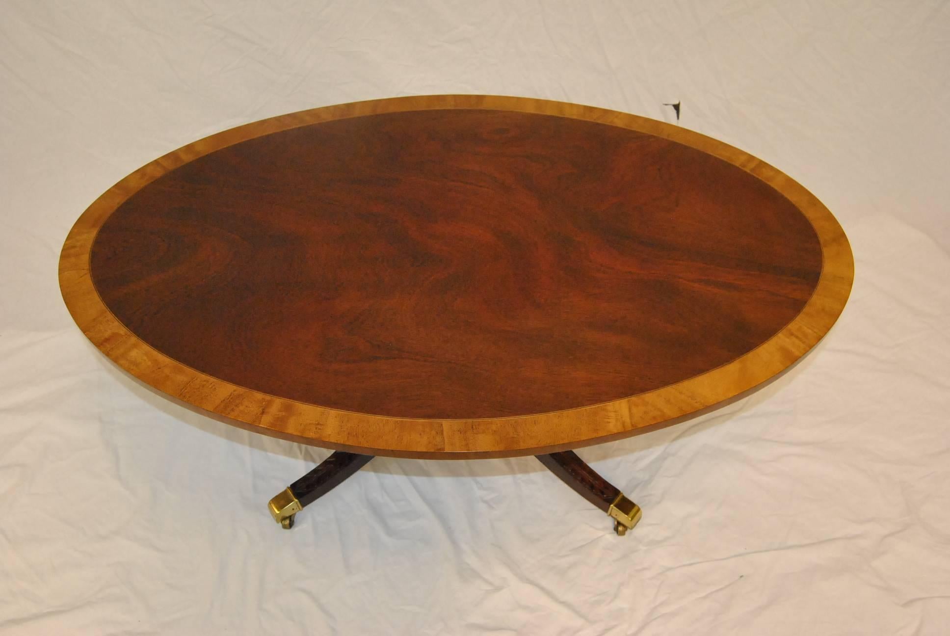 An elegant coffee table by Kindel Furniture. This beautiful piece features a banded oval top with a pedestal base and four fluted legs with capped brass feet. This will make a lovely addition to your decor.