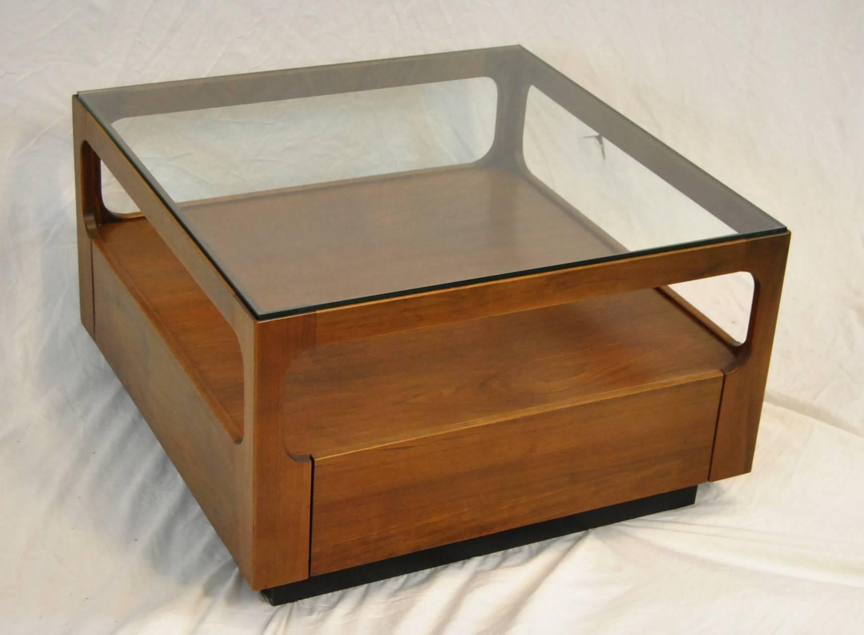 A classic Mid-Century teak coffee table with glass top designed by John Keal for Brown Saltman. Table is 30