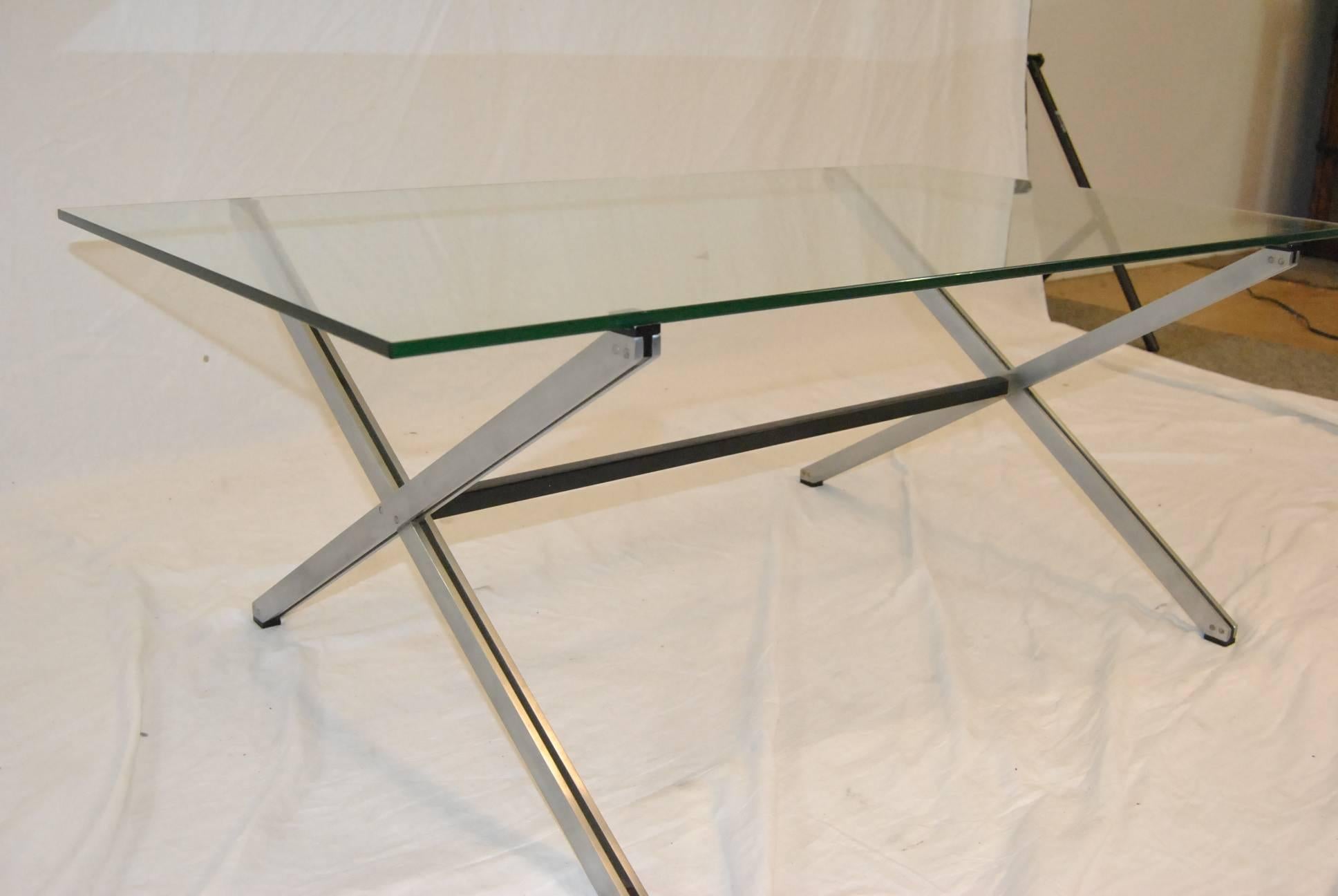 Another Classic Mid-Century design with architectural overtones by Florence Knoll. This cocktail table is part of the Parallel collection. Table features a chrome plated frame with black enamel supports in a crossed design. Frame supports a thick