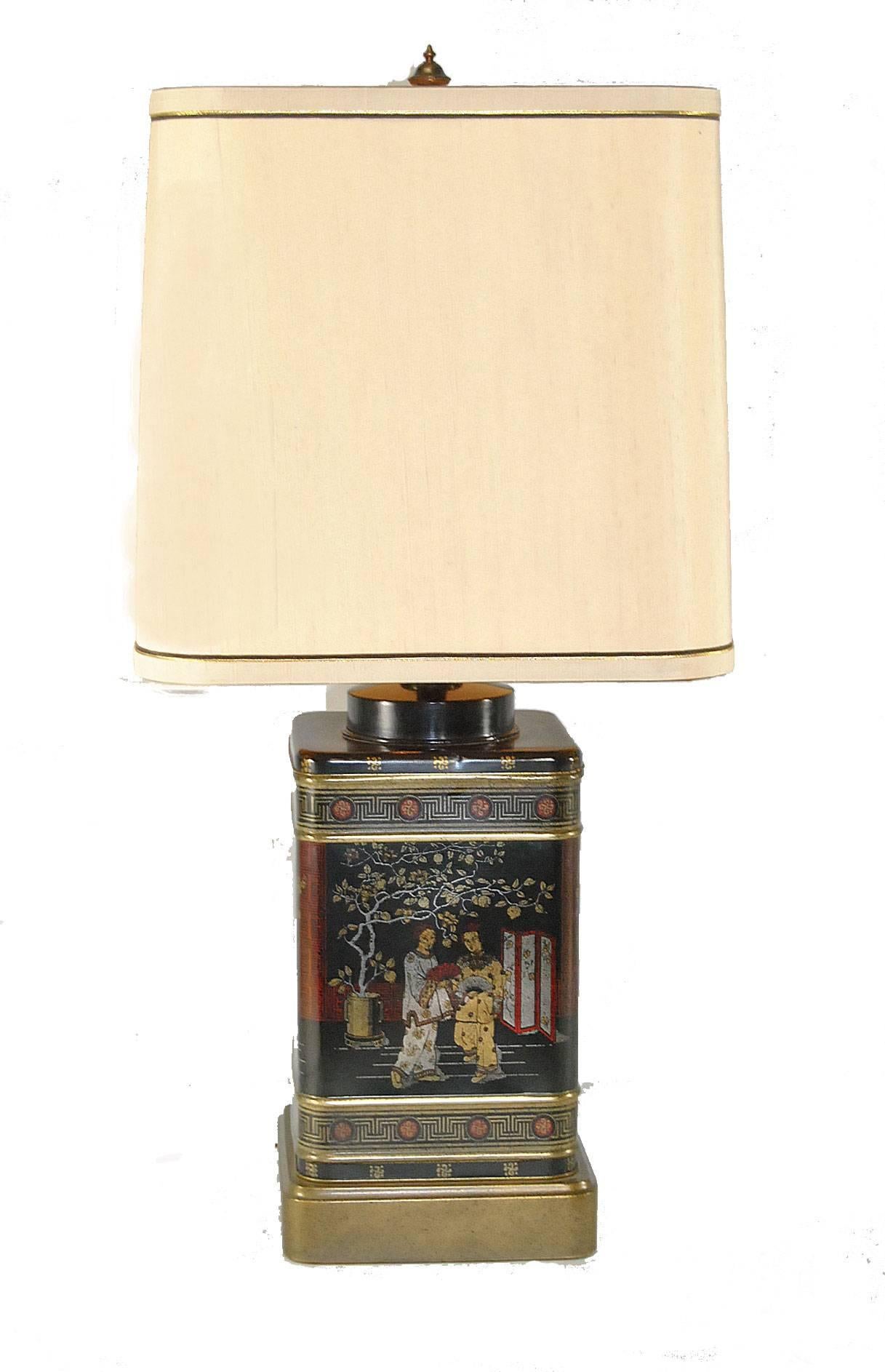 A great pair of black tin tea canister table lamps by Frederick Cooper. The pair features two different scenes on the sides. Frederick Cooper sticker on socket. Shades are not included.