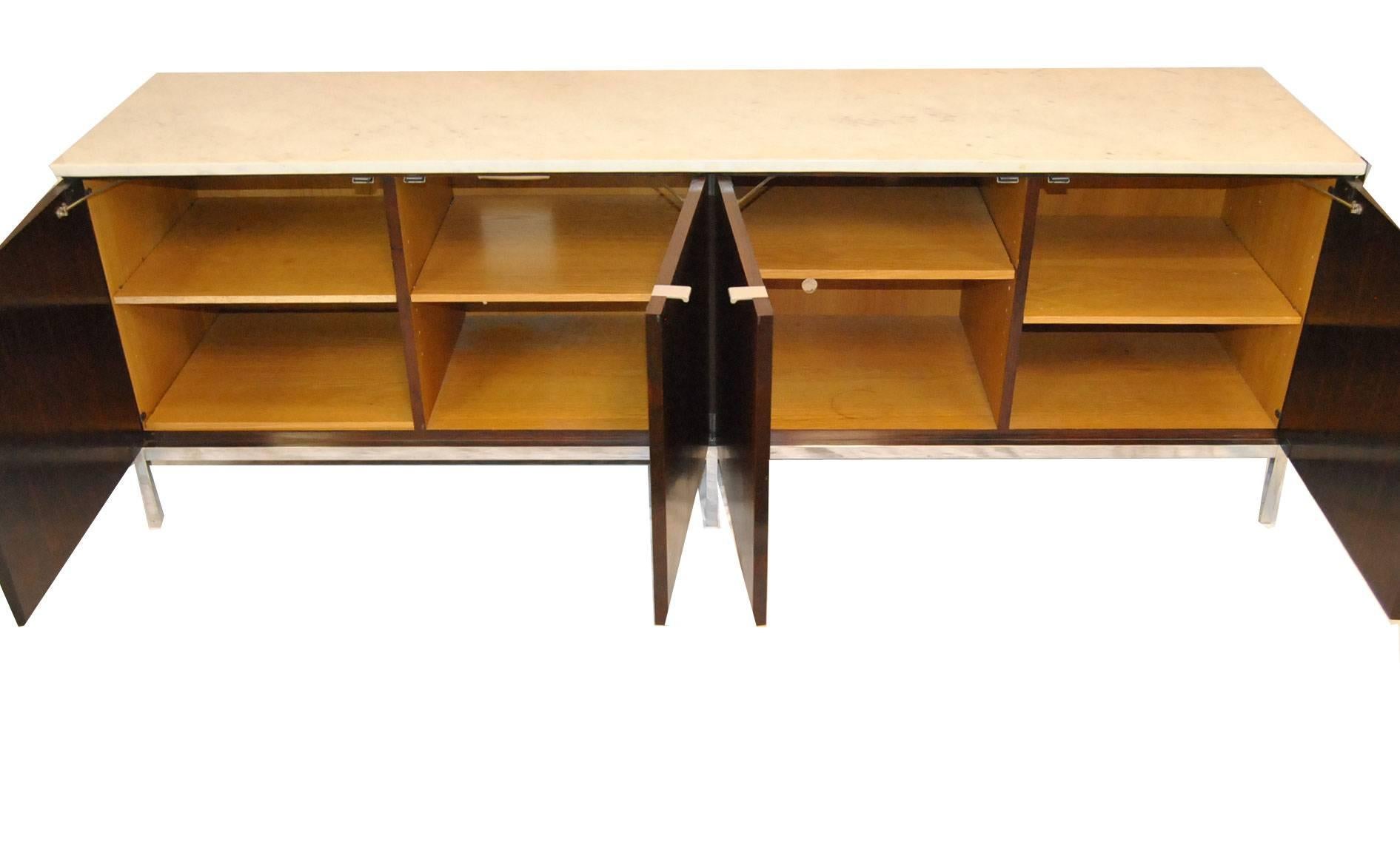 A great credenza by Florence Knoll. It features matched grain Brazilian rosewood which sits on a chrome base. The marble-top has rich veining and no stains. The interior has four storage areas with one adjustable shelf in each section. This was used