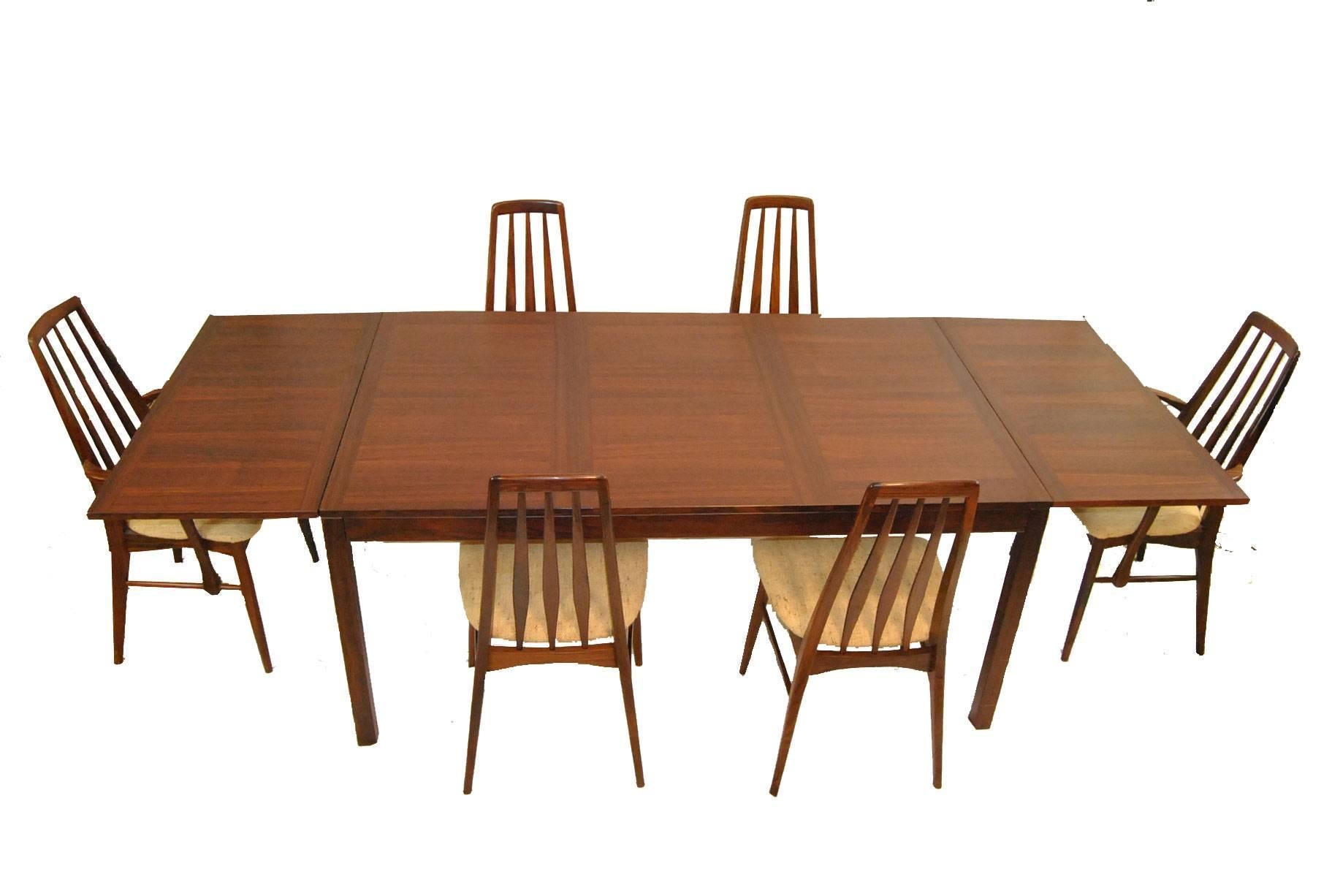 A great Mid-Century dining set in rosewood. The table has wonderful rich graining and is 65" long by 39.5" wide with two 19.5" leafs. Leafs can be removed or dropped down to the side. Table is by Vejle Stole, Mobelfabrik, Denmark and