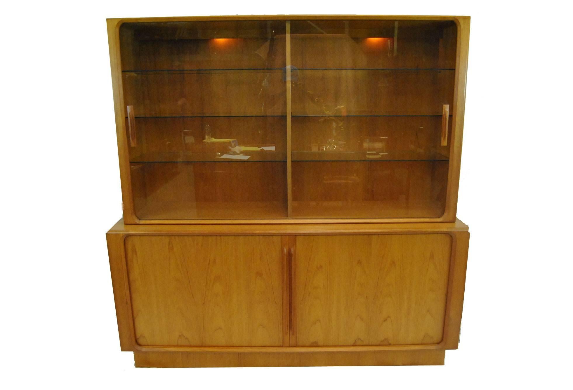 A great teak sideboard by Bernhard Pedersen & Son, made in Denmark. Can be used with our without the top. This beautiful piece features a light display top with two glass sliding doors with six glass shelves. The lower section has four shelves,