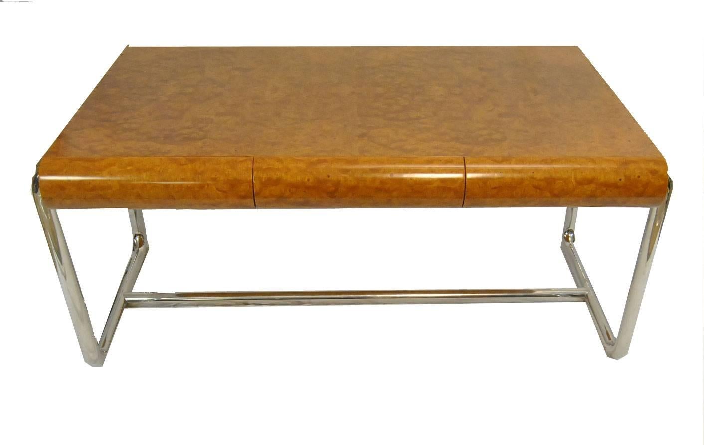 A great Mid-Century Modern burled wood desk designed by Leon Rosen for the Pace Collection. This desk features three curved drawers that blend in with the overall clean design. 2" curved tubular chrome-plated legs with central support hold the