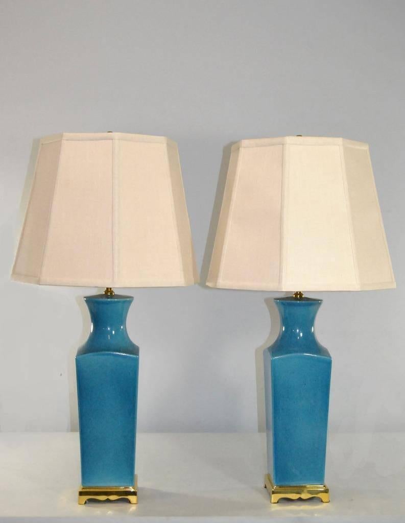 A beautiful pair of table lamps by Paul Hanson. They feature a turquoise blue base with black flecks throughout and polished brass trim. Both lamps have part of the original Paul Hanson label. Very good condition with good wiring. The dimensions are