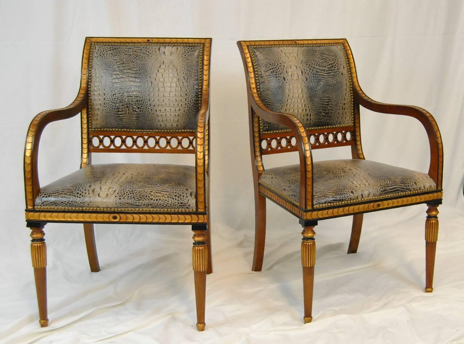 A great pair of Regency style armchairs by Whittemore Sherrill. The chairs feature crocodile upholstery. Gold scale like carvings accent the back, arms and skirt of each chair. Tapering fluted legs with black accents complete the look. This unusual